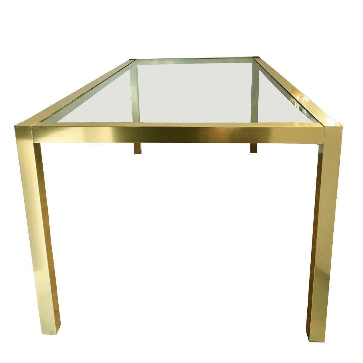 Large Mid-Century Modern brass-plated gold tone metal and glass parsons style dining table. This long rectangular shaped parsons style table features square legs and a thick removable clear glass top. Would also make a great over sized desk. In the