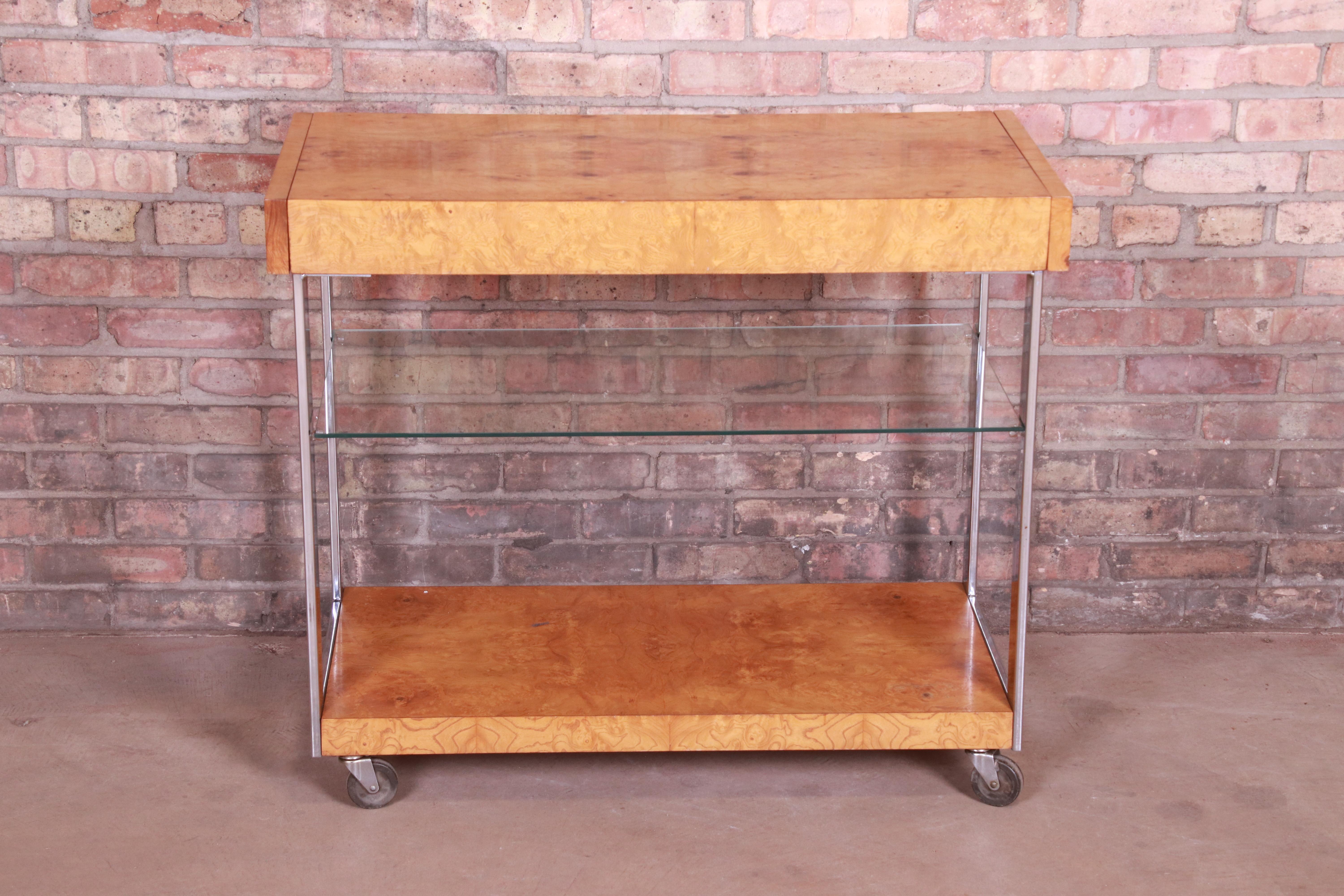 An exceptional Mid-Century Modern extension bar cart

In the manner of Milo Baughman

By Lane Furniture

USA, 1970s

Book-matched burled olive wood, with chrome legs, a single glass shelf, and original casters.

Measures: 36.13