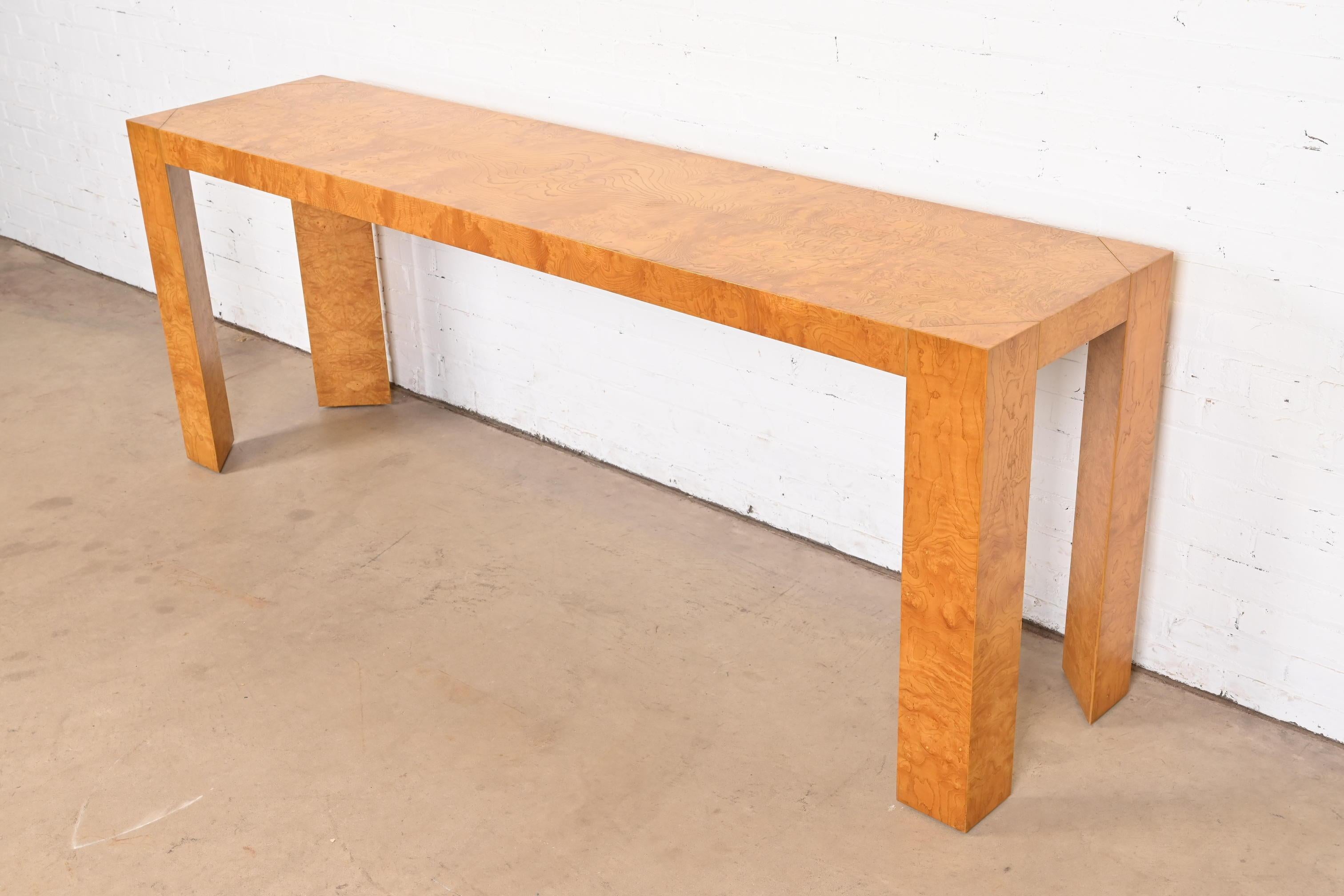 Una magnífica consola o mesa de sofá de madera burl de estilo Moderno de Mediados de Siglo

A la manera de Milo Baughman

EE.UU., alrededor de 1970

Preciosa madera de olivo burilada, con patas triangulares únicas.

Medidas: 84