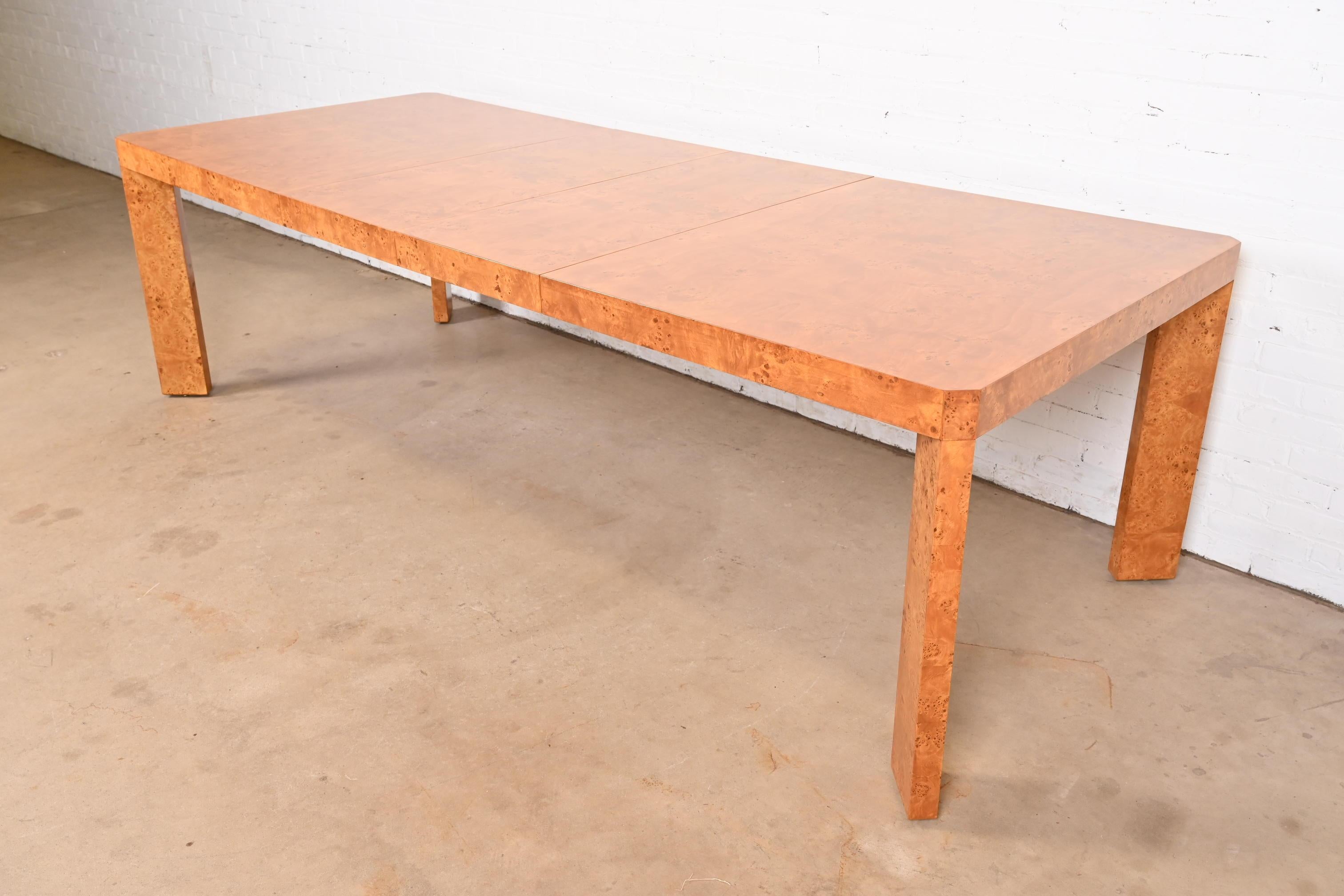Exceptionnelle table de salle à manger à rallonge Parsons de style moderne du milieu du siècle, en superbe bois d'olivier ronceux assorti aux livres.

À la manière de Milo Baughman

USA, Circa 1970s

Dimensions : 68 