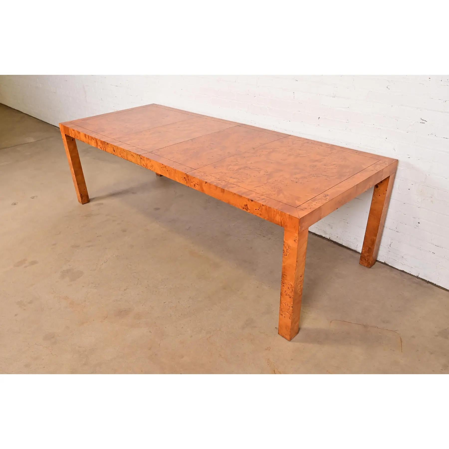 An exceptional Mid-Century Modern Parsons extension dining table in gorgeous book-matched burled olive wood

In the manner of Milo Baughman

USA, Circa 1970s

Measures: 60