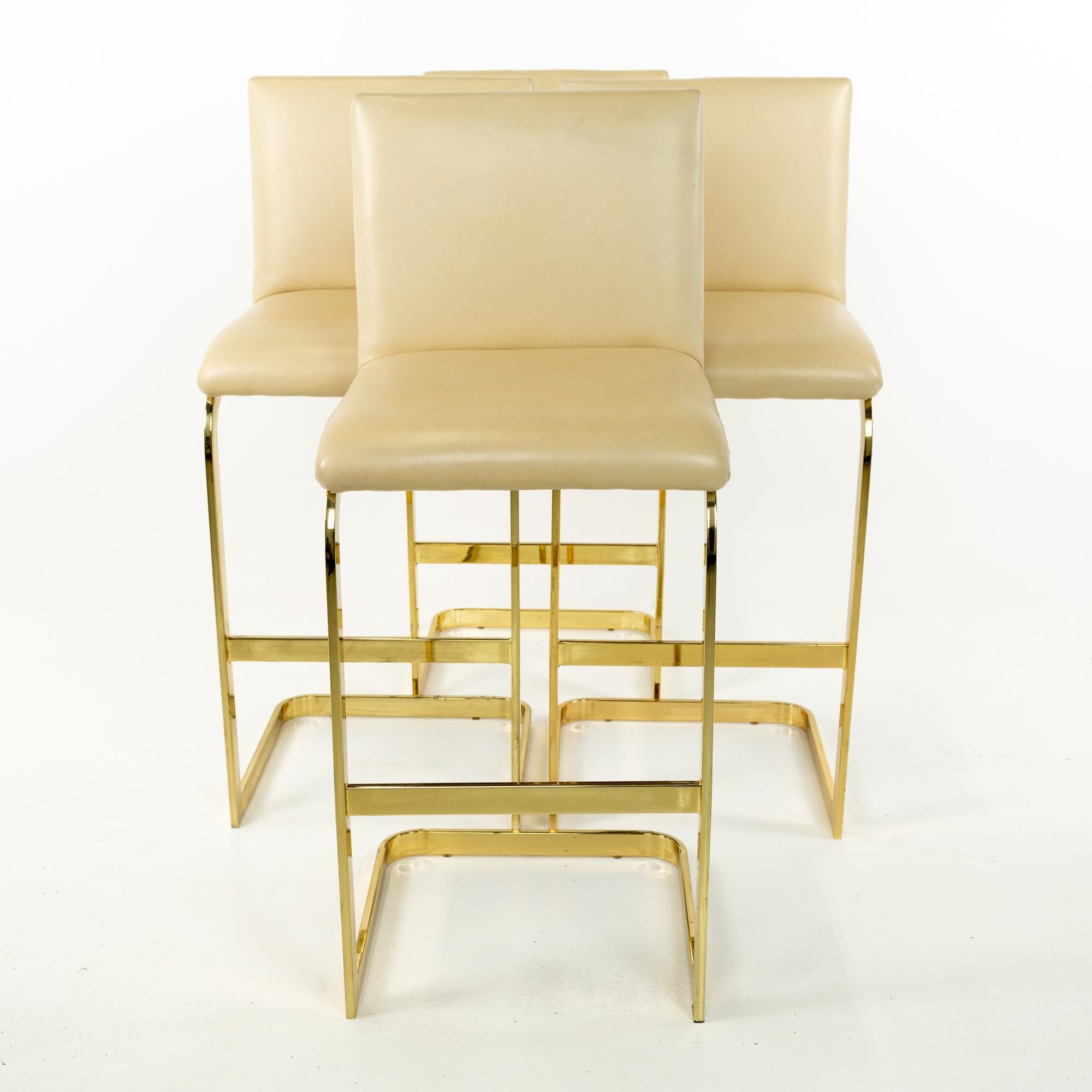 Milo Baughman style Mid Century brass and cream upholstered cantilever bar stools, set of 4
These chairs are 18.5 wide x 17.75 deep x 43 inches high, the seat height is 30 inches

This piece is available in what we call restored vintage condition.