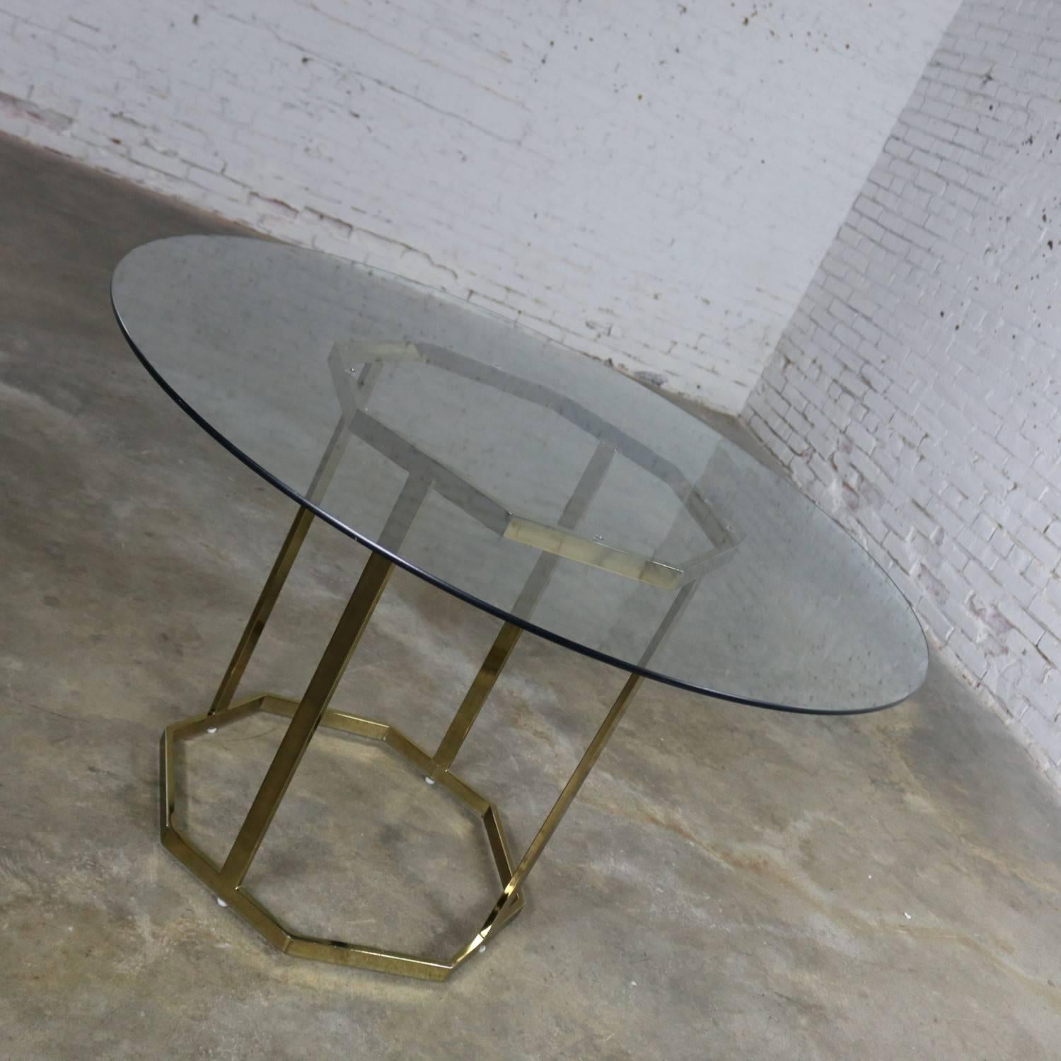 Handsome brass-plated metal tube octagon dining table base with round 3/8 inch glass top in the style of Milo Baughman for Thayer Coggin. This table is in very good original vintage condition. The base has some minor scratching and loss of plating