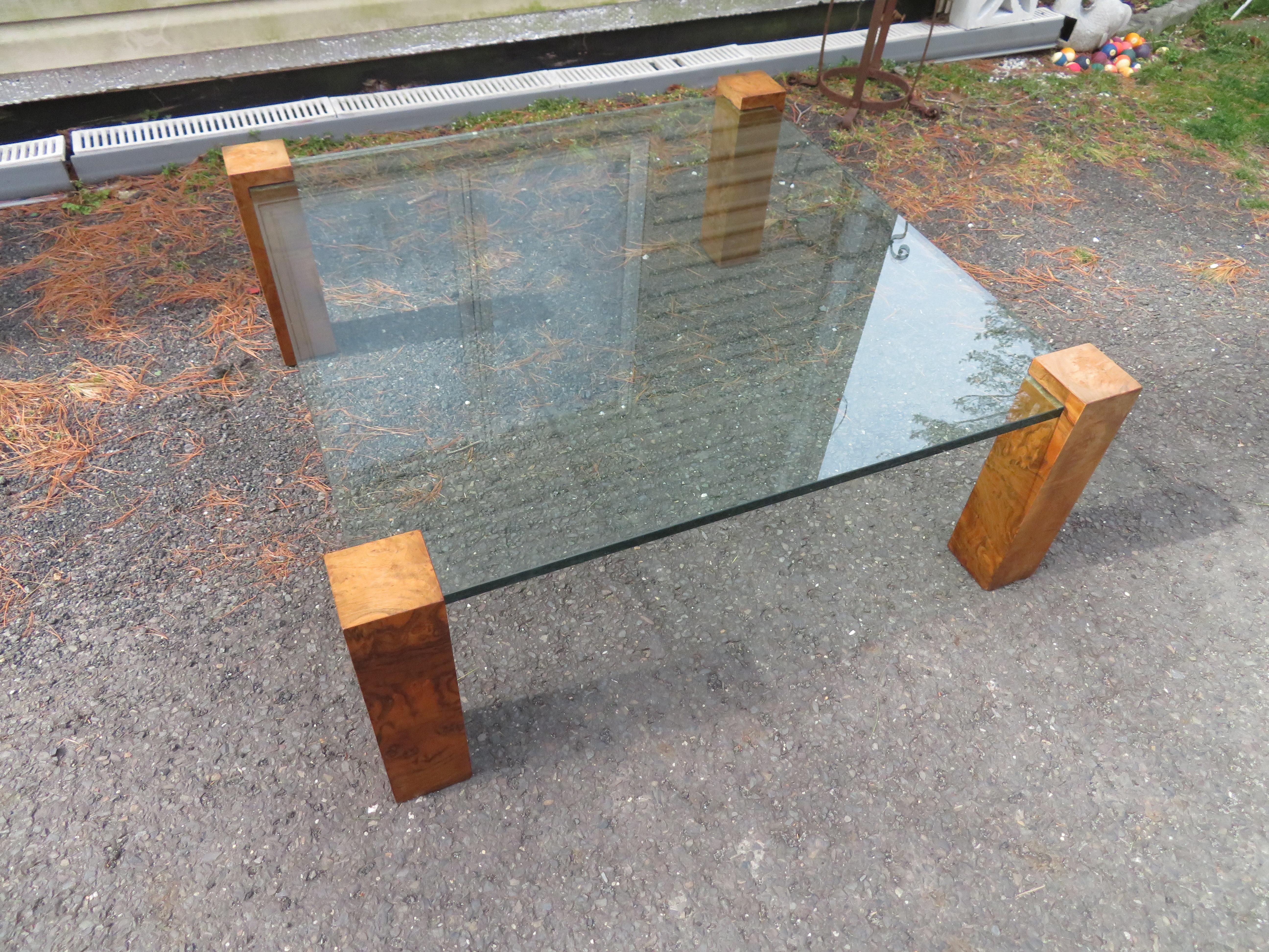 Merveilleuse table basse en verre et colonnes en bois d'olivier de Milo Baughman.  Nous aimons la simplicité des 4 colonnes rectangulaires qui soutiennent un plateau en verre carré de 3/4