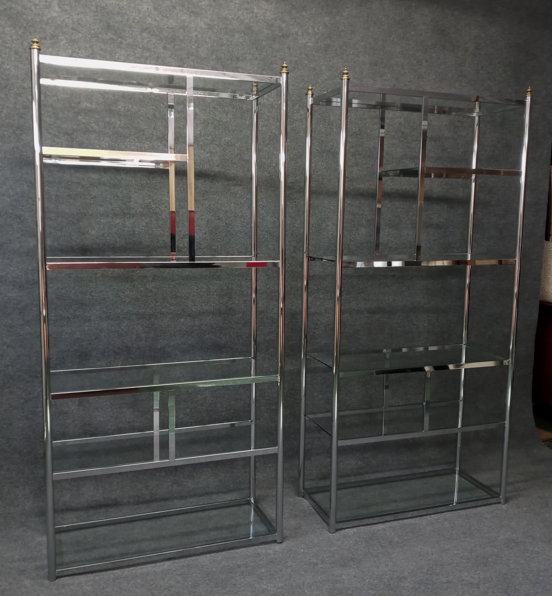 A stunning pair of vintage etagere in the style of Milo Baughman. These vintage and truly classic pieces have the iconic styling that Milo Baughman made so popular. The a-symmetric frames support glass shelves from bottom to top and are capped off