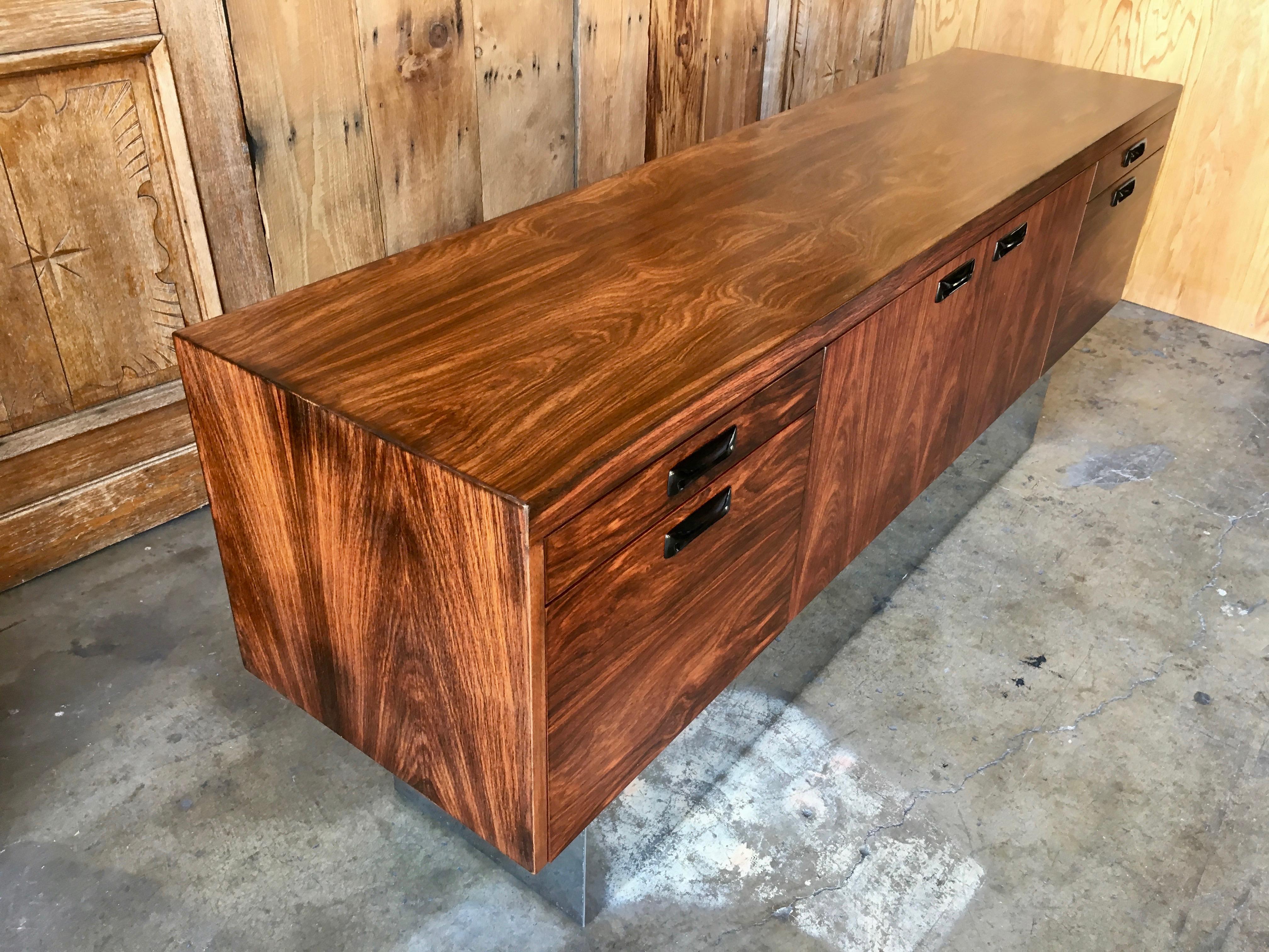Rosewood and chrome credenza with two large file drawers and two pencil drawers also two doors in the center for extra storage This piece is also finished on the back.
 