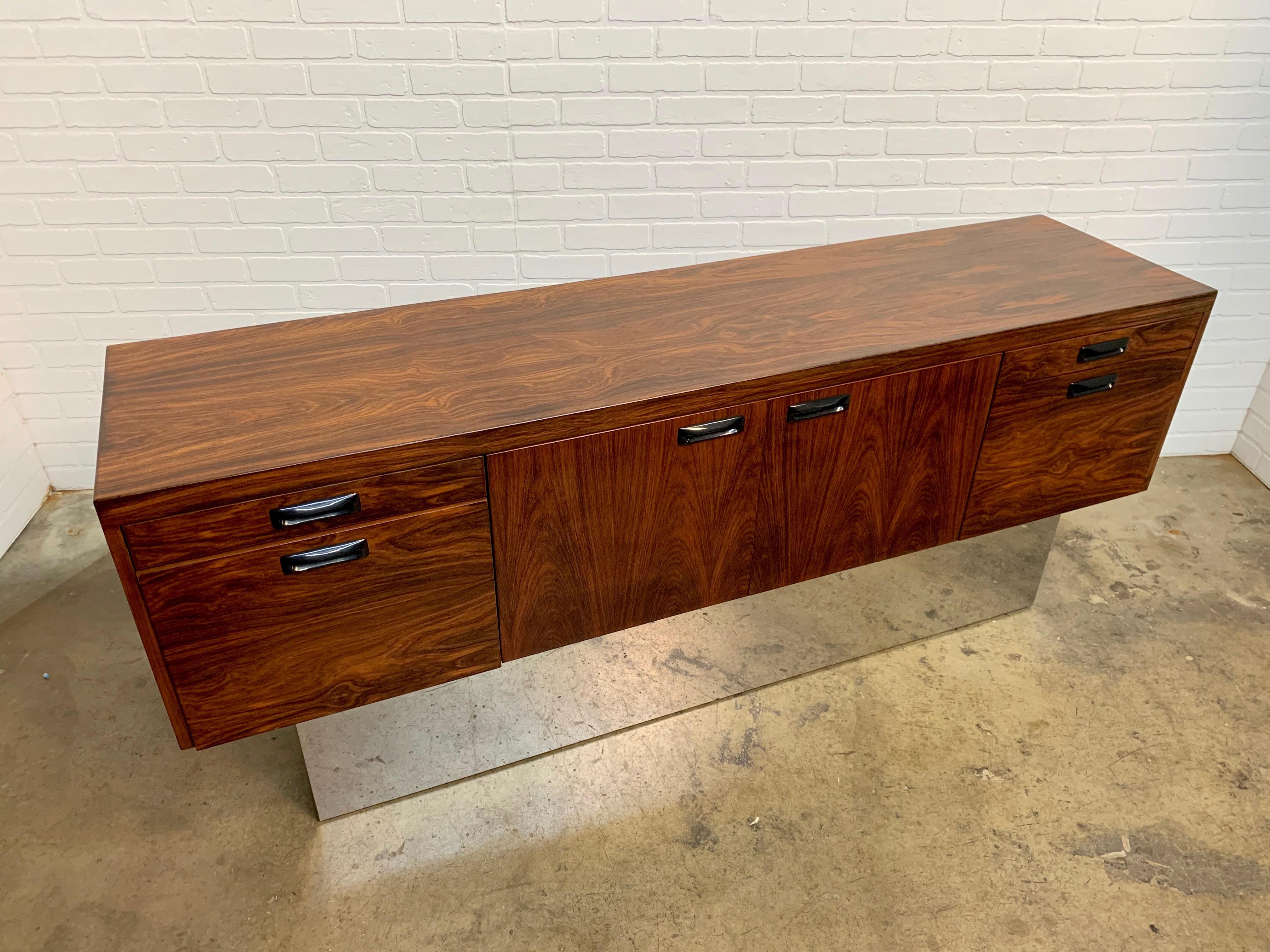 Rosewood and chrome credenza with two large file drawers and two pencil drawers also two doors in the center for extra storage This piece is also finished on the back.
   