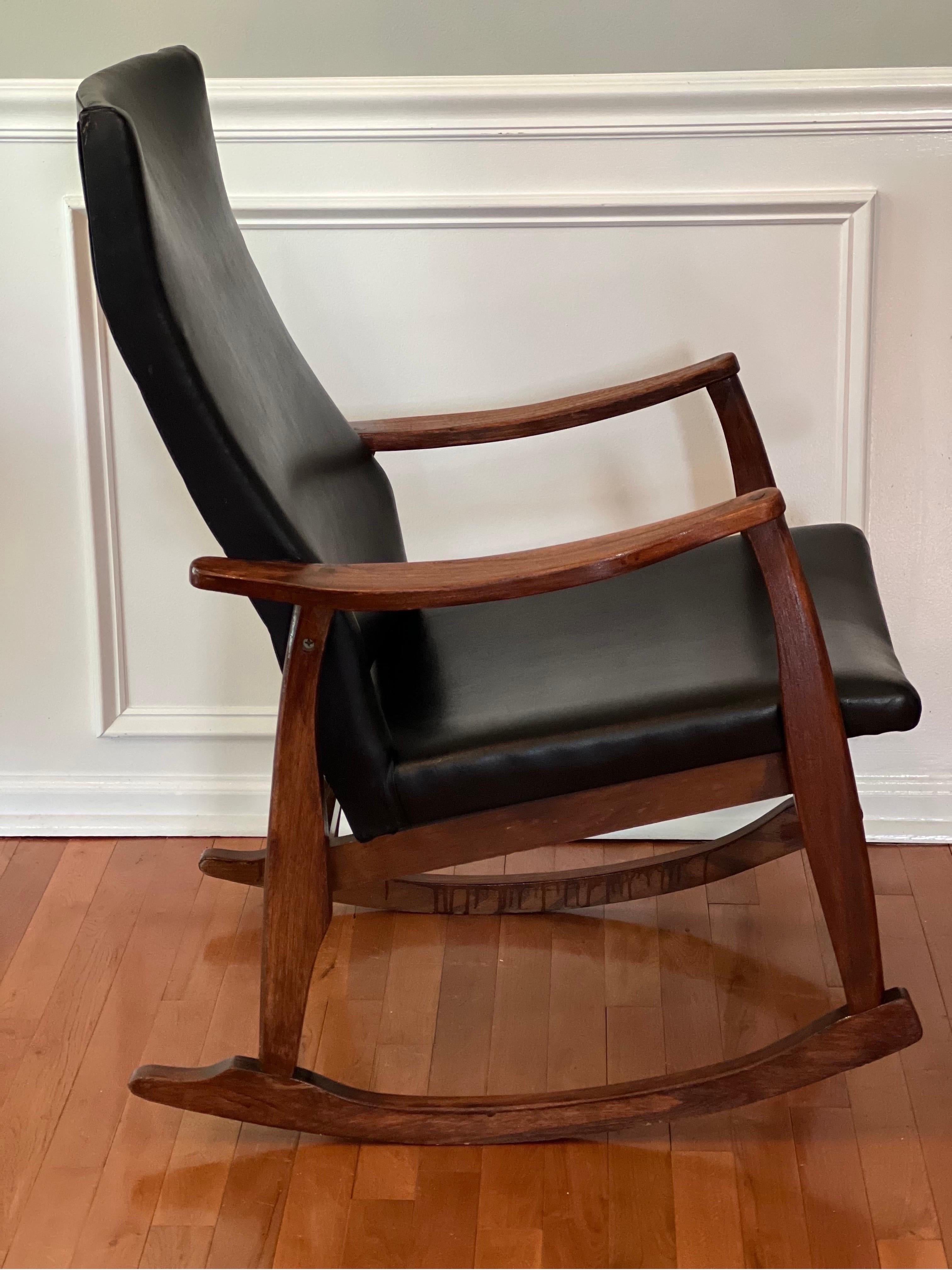 Elegante sedia a dondolo vintage di metà secolo nello stile di Milo Baughman. Questa comoda sedia a dondolo presenta una robusta struttura in legno massiccio con cuscini in naugahyde nero in ottime condizioni. Un pezzo bellissimo.