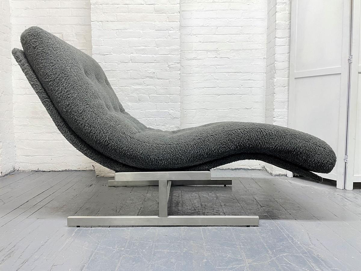 Milo Baughman style wave chaise lounge with polished chrome pedestal base. Upholstered in a gray faux curly sheepskin fabric.