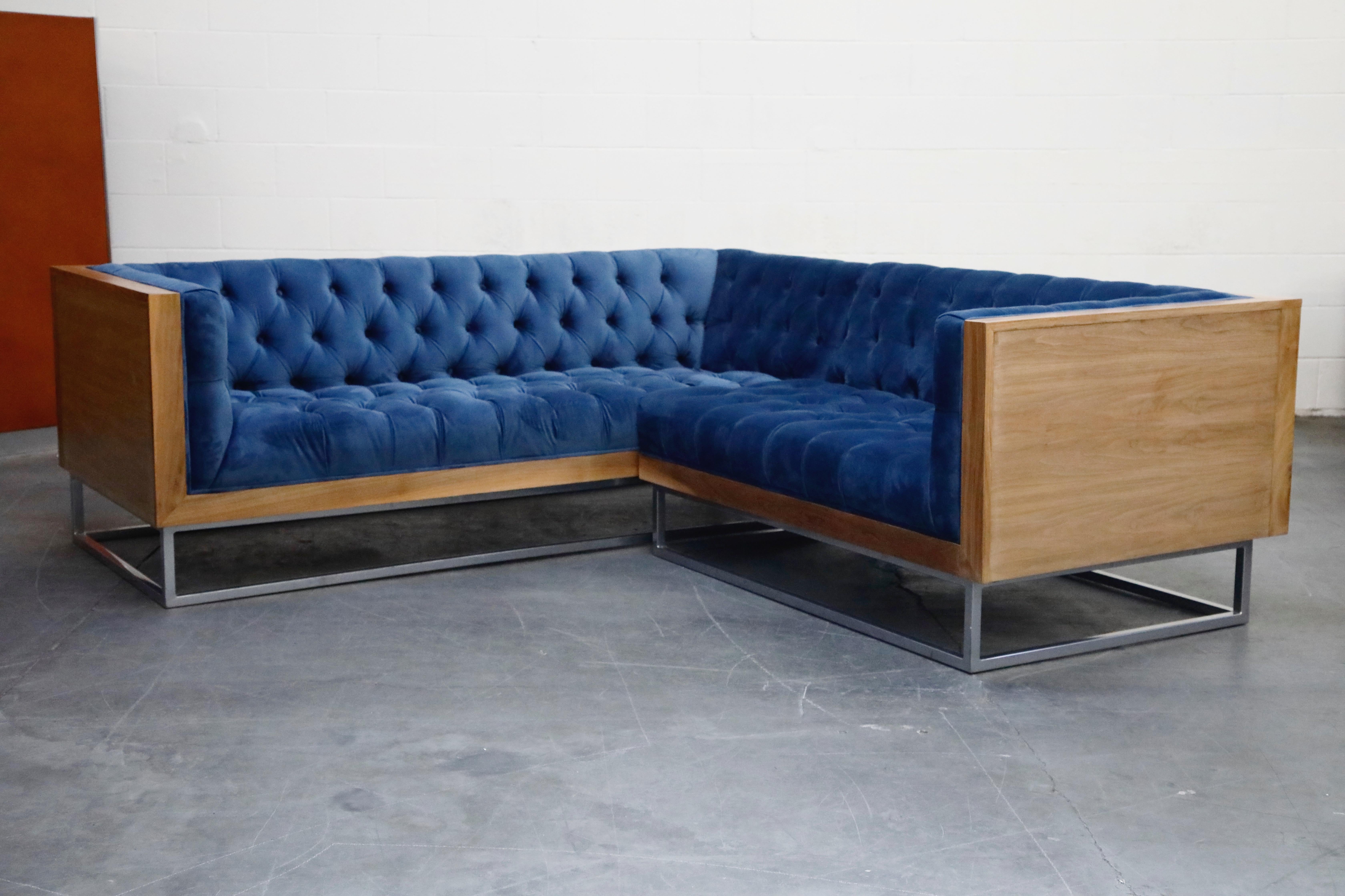 This high quality, well made, custom sectional sofa in the style of Milo Baughman for Thayer Coggin features a hefty wood case design floating on top of a thick steel base. The vibrant blue velvet tufted upholstery features one row of buttons in