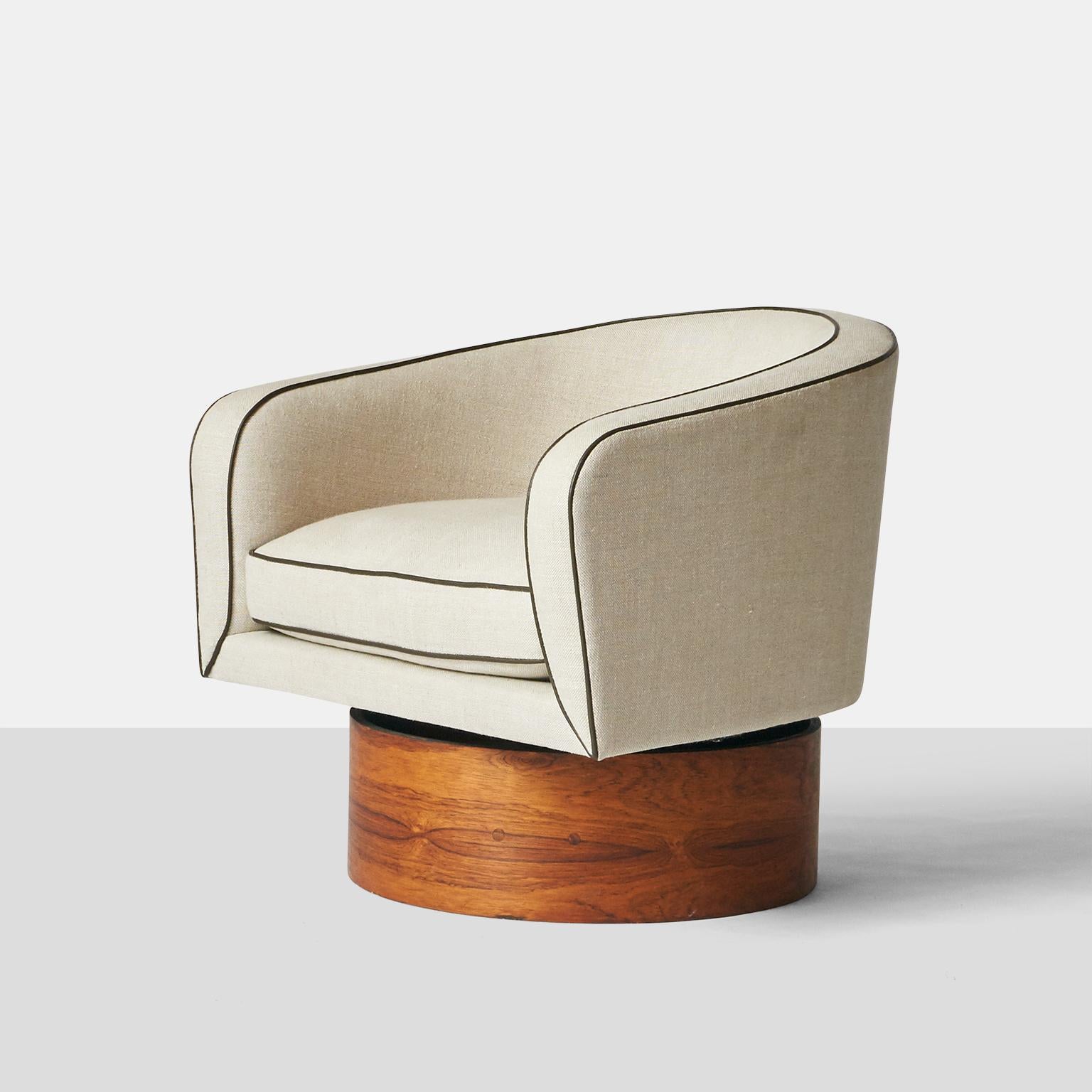 A tall, Barrel shaped club chair by Milo Baughman for Thayer Coggin. Features a high, cushioned seat, and round walnut base. Shown in beige linen, with contrasting brown piping.