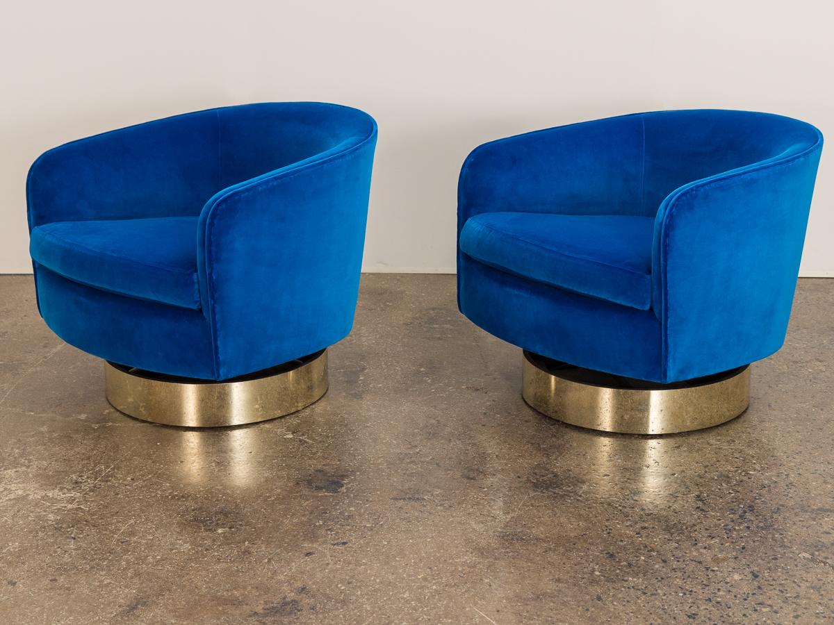 Pair of glamorous 1970s velvet swivel lounge chairs, designed by Milo Baughman for Thayer Coggin. These plush chairs have a tilt feature for added function and comfort. Gleaming gilt bases have been restored with new brass plating. Newly recovered