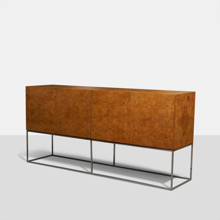 Tall burl wood credenza by Milo Baughman for Thayer Coggin. Beautiful olive wood case supported by open chromed steel base. White lacquered interior with two hidden drawers.