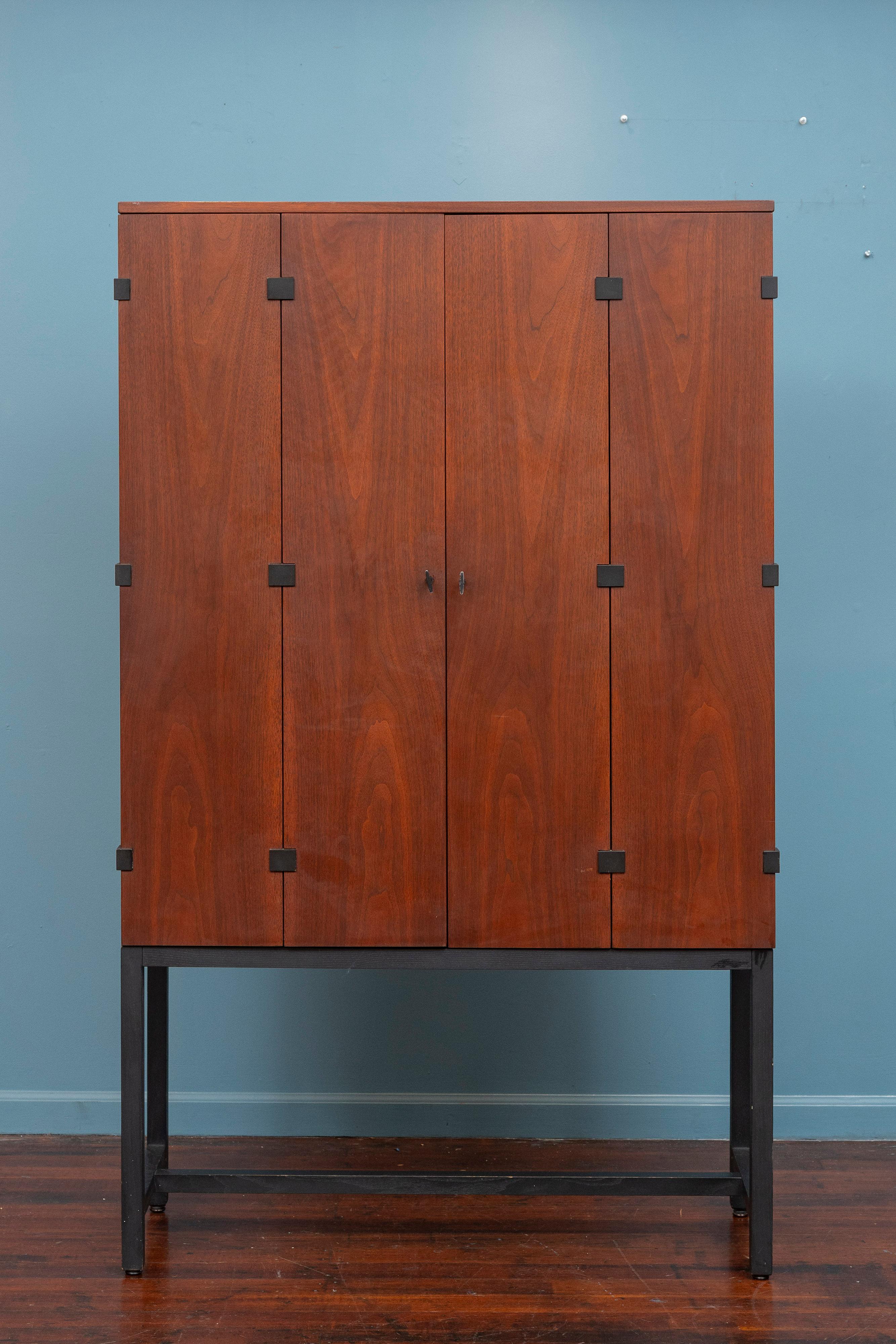 Milo Baughman Design Tall Cabinet or Dry Bar for Directional Furniture Company, U.S.A. Elegant and sophisticated design by one of America's most successful furniture designer's. Figured walnut bifold doors reveal an interior of adjustable shelves