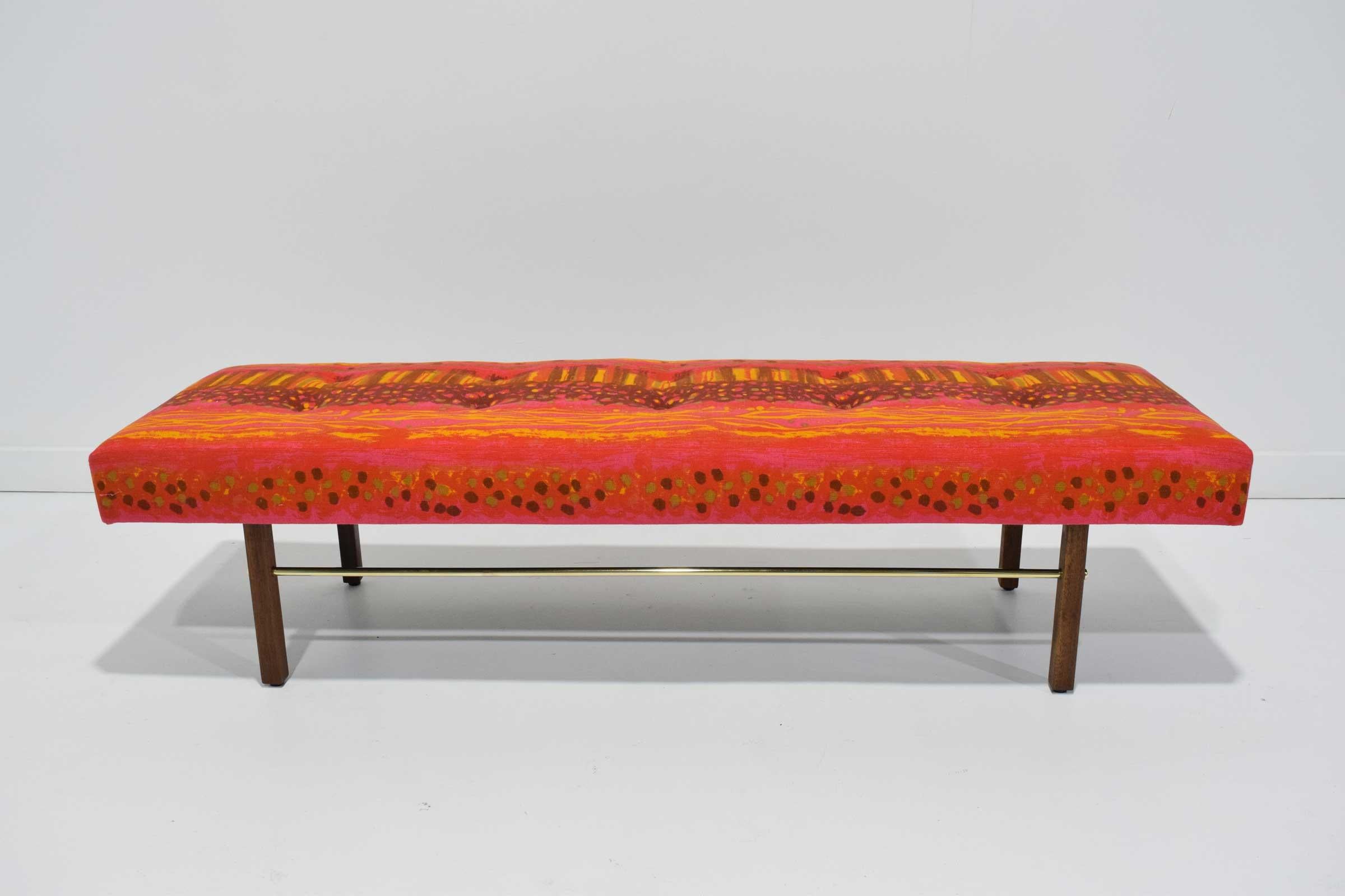 Fully restored. A beautiful midcentury bench by Milo Baughman for Thayer Coggin. Walnut legs, brass stretcher. New upholstery by Jack Lenor Larsen. A 1960s fabric in vibrant pink, brown, yellow and orange.