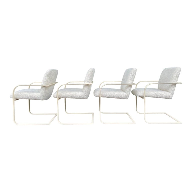 Set of four signed Milo Baughman sculptural cantilever dining arm chairs newly professionally re-upholstered with very soft and textural high end luxury curly boucle fabric by Barbara Barry for Kravet in a neutral ivory cream tone. 

These