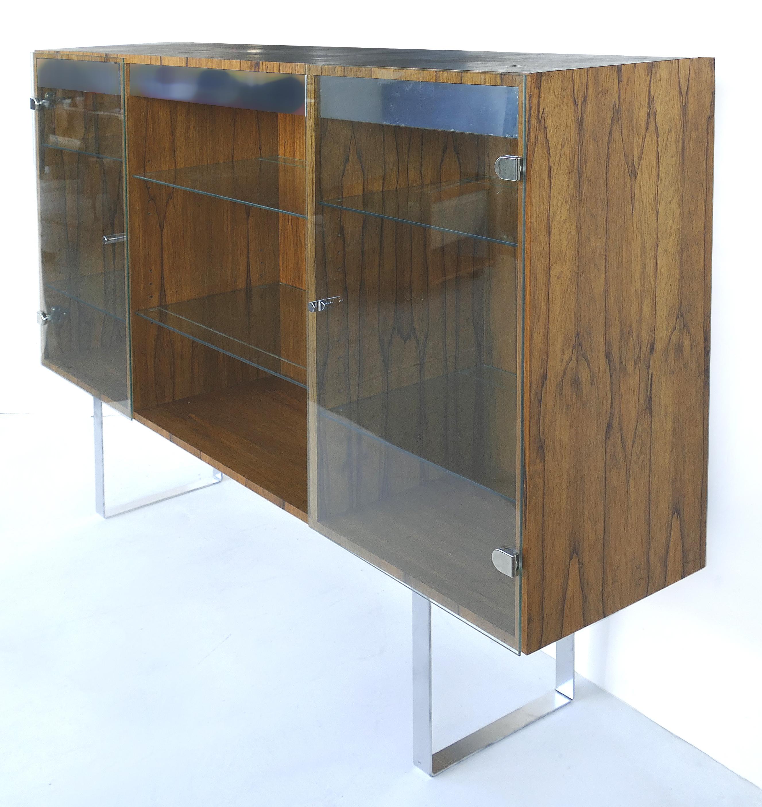 Milo Baughman Thayer Coggin rosewood Vitrine with glass doors and adjustable shelves

Offered for sale is a Milo Baughman rosewood vitrine which is raised on stainless steel legs. The rosewood case has glass doors that open to reveal adjustable