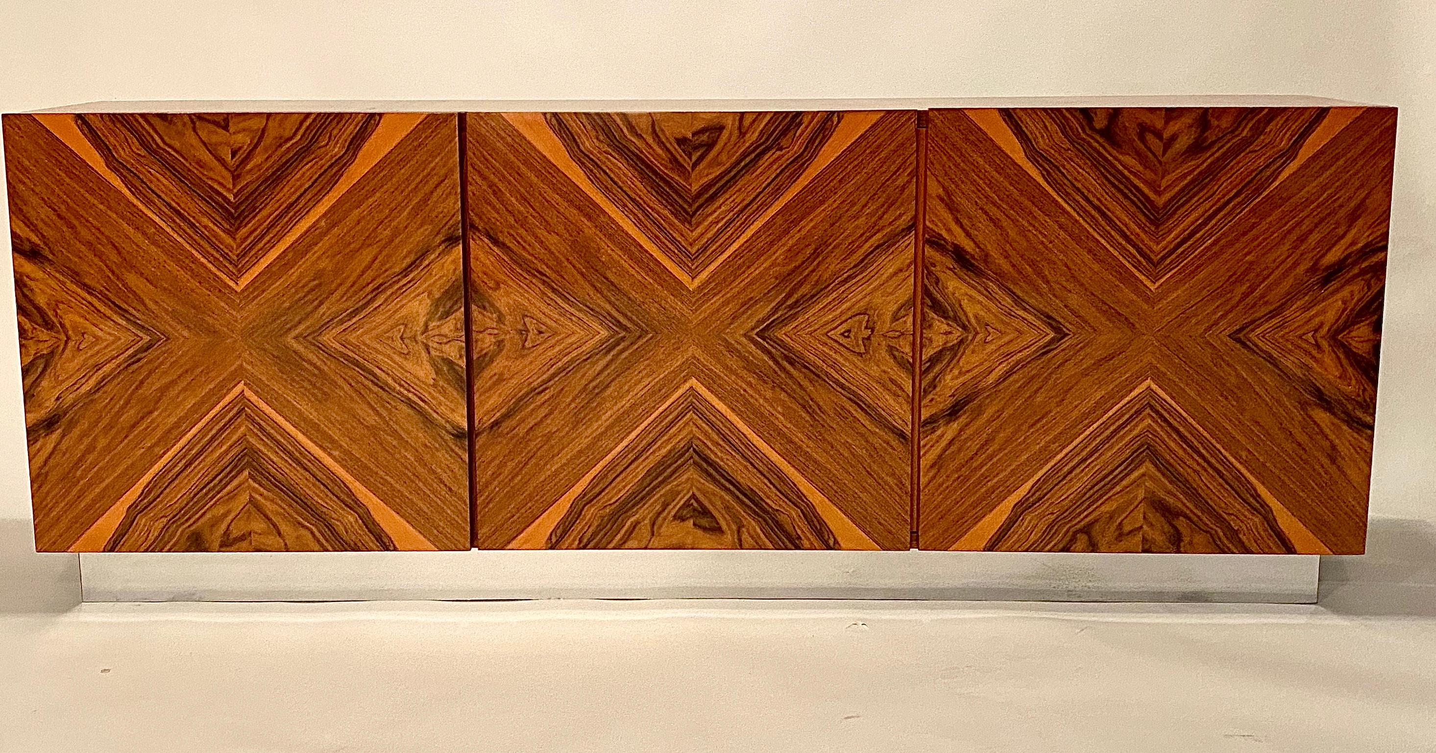 Rosewood wall mounted cabinet designed by Milo Baughman for Thayer Coggin. This rare floating wall cabinet is made in a gorgeous rosewood parquetry with a French polish finish and a chrome plinth. 

The three cabinet doors open to reveal two