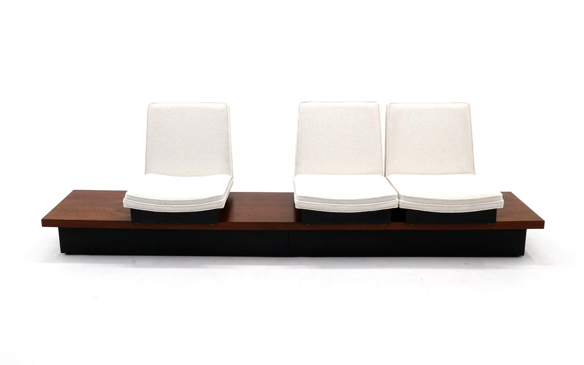 Something we have never seen. Designed by Milo Baughman and made by Thayer Coggin, this is a three seat seating unit that consists of a nine foot long bench style platform of walnut with a black lacquered plinth base. The three seats which have been