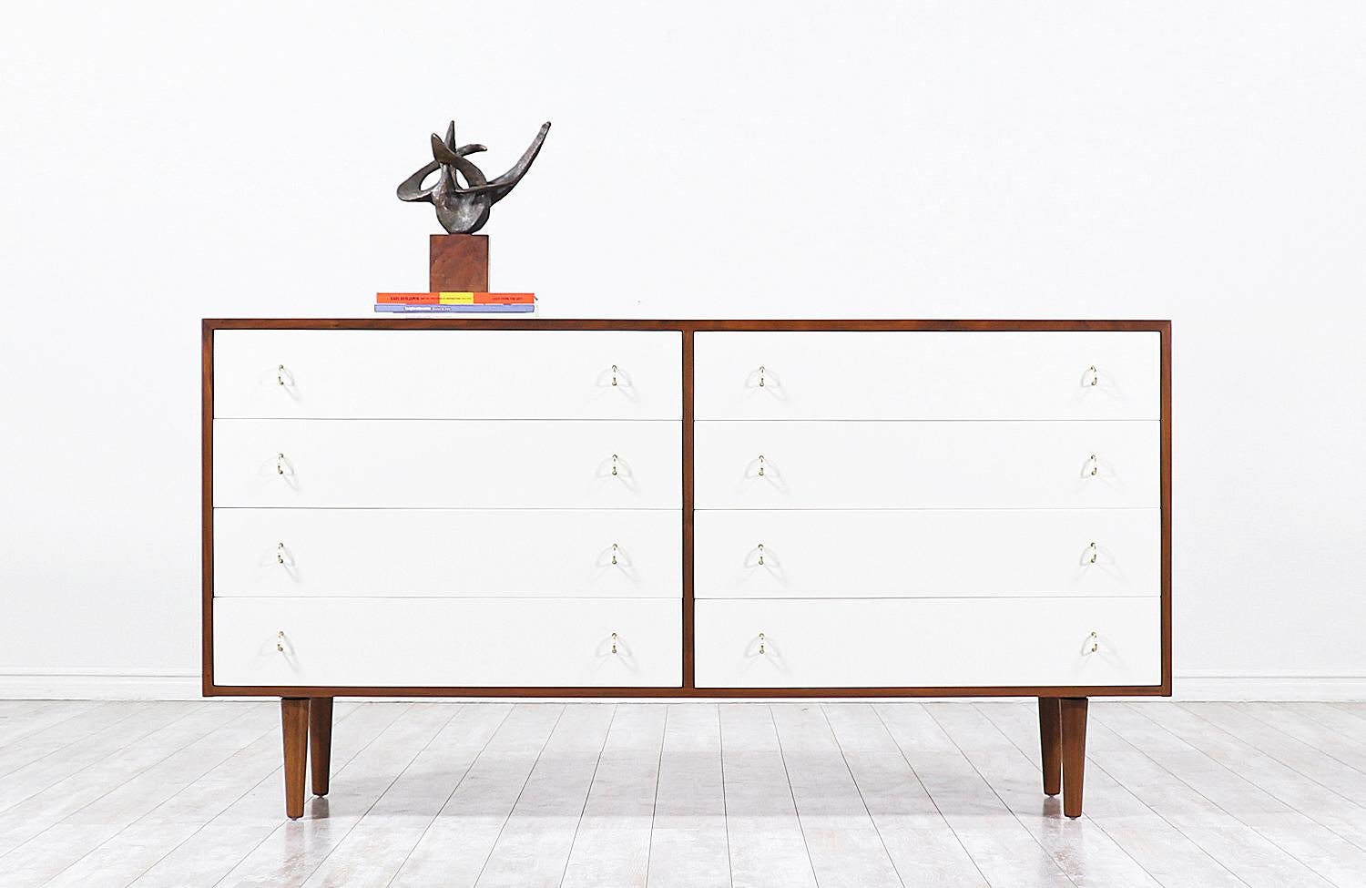 Elegant Mid-Century Modern two-tone dresser designed by Milo Baughman for Glenn of California in the United States circa 1950s. This spectacular eight-drawer dresser features a sturdy walnut wood case with a custom high-polished ivory lacquered