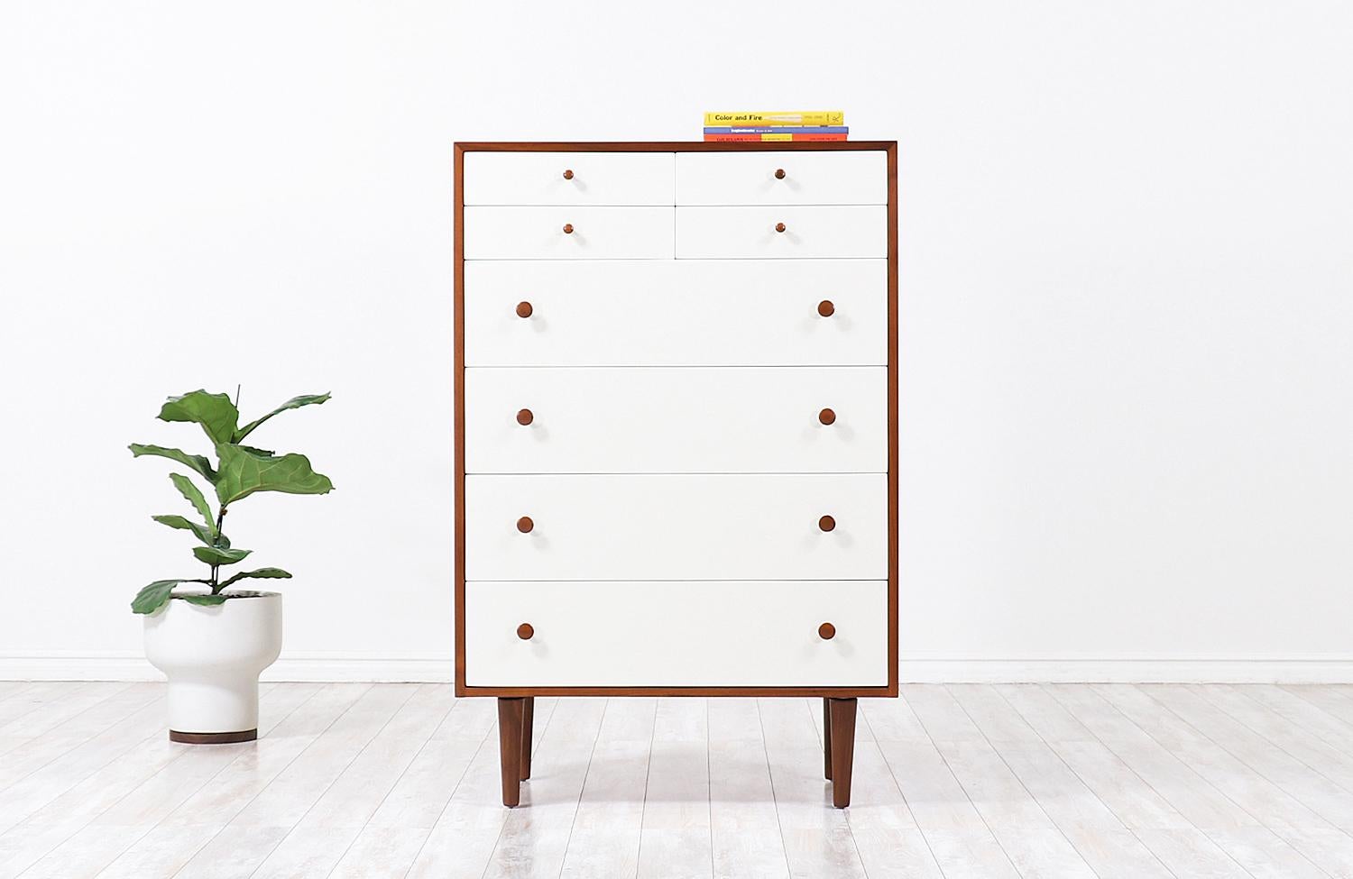 Elegant modern chest of drawers designed Glenn of California in the United States, circa 1950s. This tall and spacious chest design features a solid walnut wood construction with eight lacquered drawers that vary in size, adding a fun geometric
