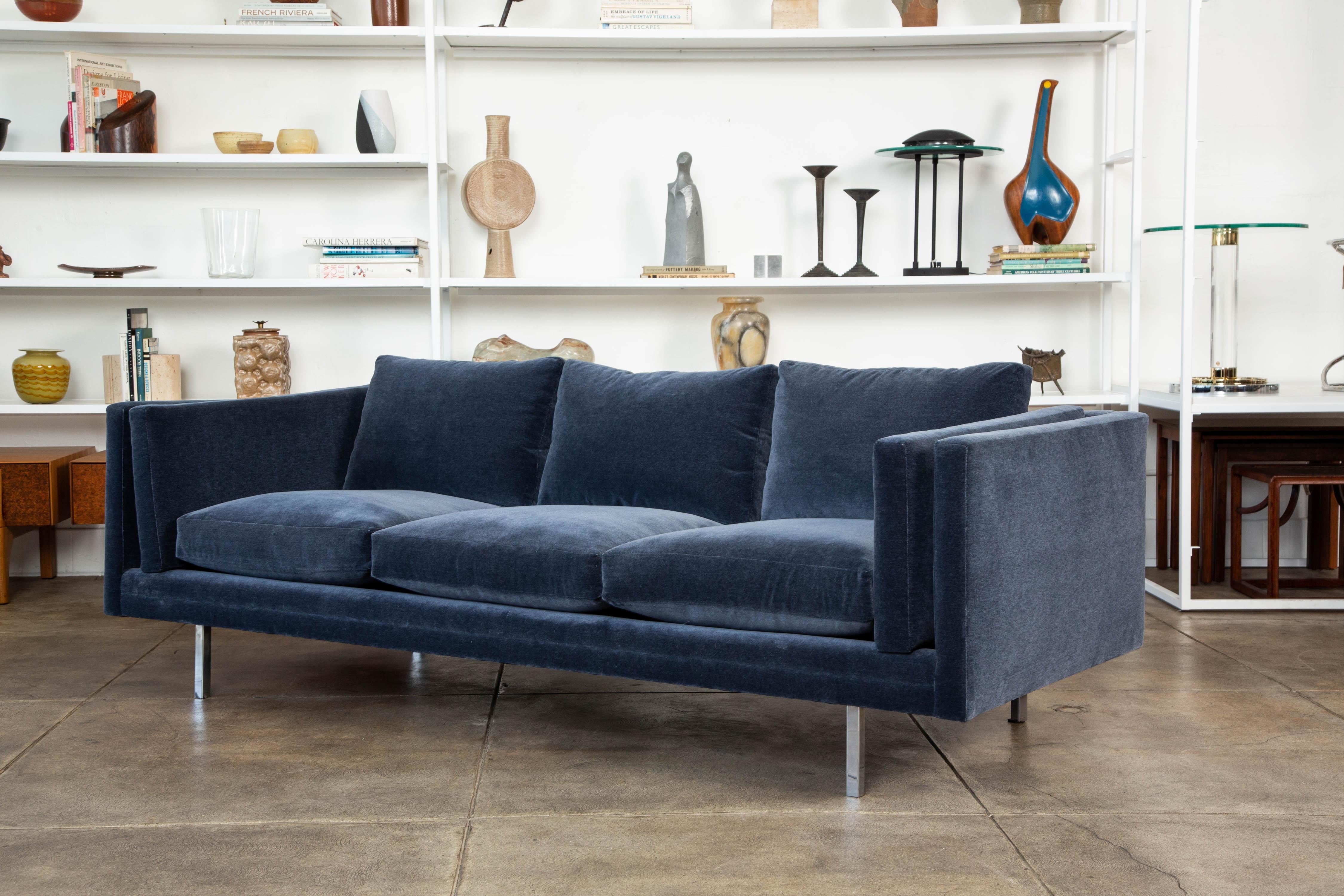 A classic sofa by Milo Baughman for Thayer Coggin, circa 1960s. The sofa has been reupholstered in a elegant navy blue Italian cotton velvet and the long, horizontal design appears to float above the ground on four chrome-plated legs. Retains the