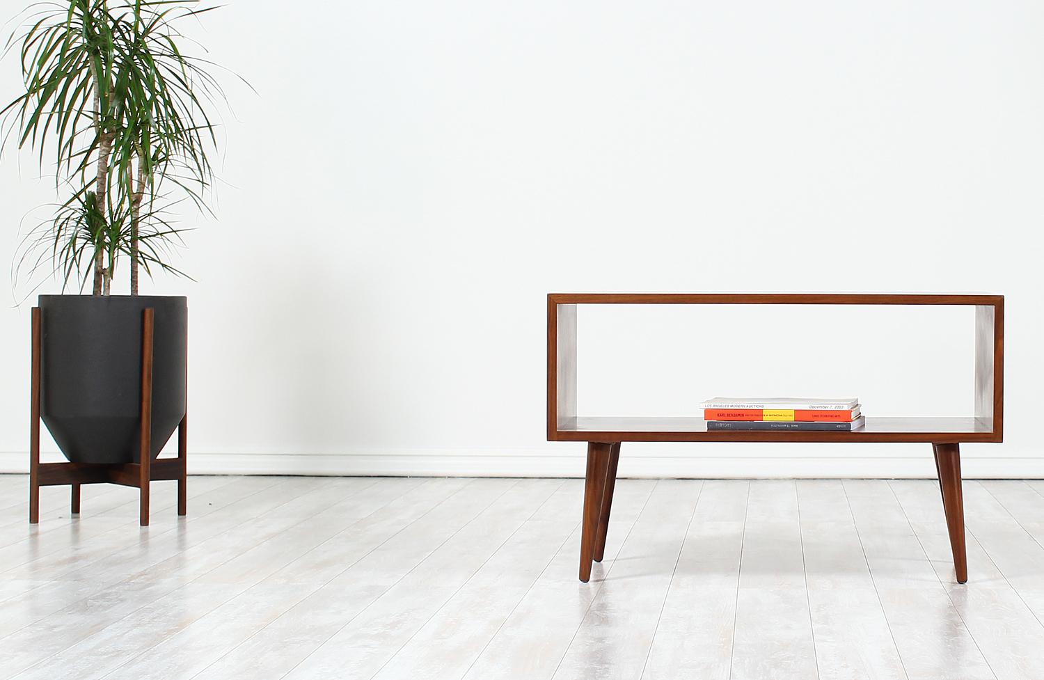 Minimalist console table designed by Milo Baughman for Glenn of California in the United States circa 1950’s. This Mid-Century Modern classic design features a solidly crafted walnut wood open rectangular case providing various display and usage