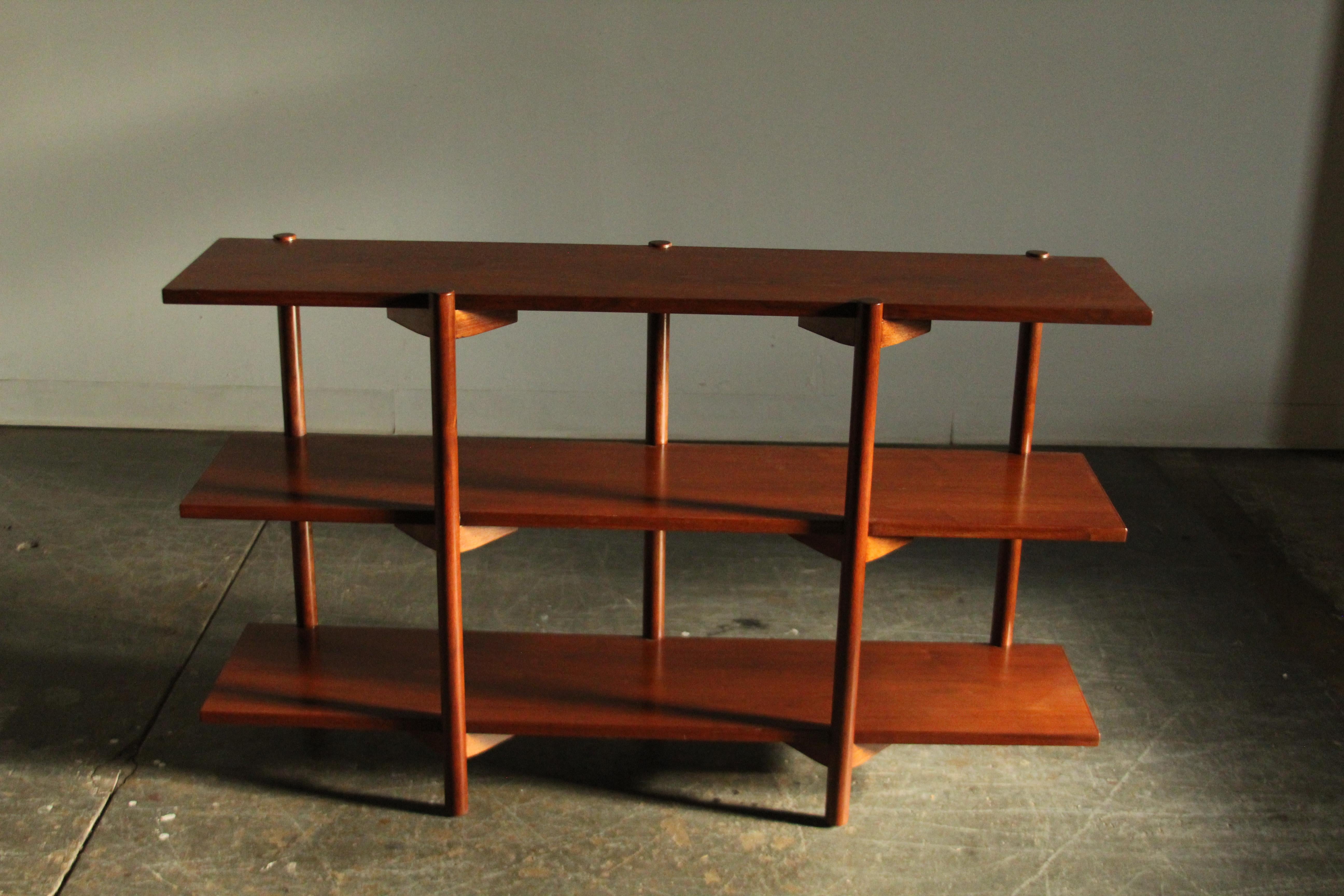 Libreria in noce di Milo Baughman prodotta da Glenn of California nel 1955. Questo design intelligente presenta tre ripiani e cinque gambe in noce massiccio sostenute da staffe alate. È perfetto per esporre le tue piante, le tue ceramiche o i tuoi