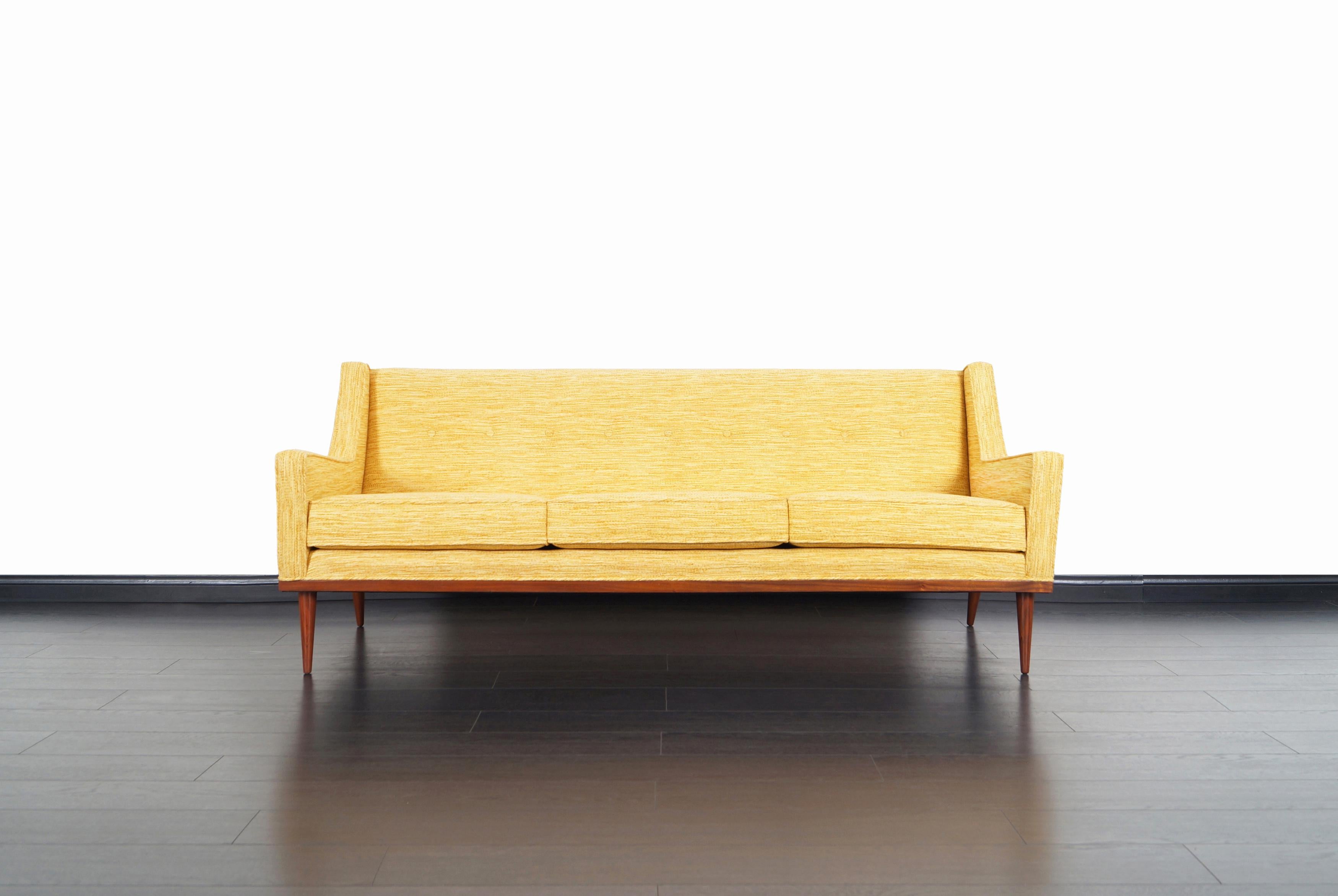 Fabulous mid-century sofa designed by Milo Baughman for James Inc. in the United States, circa 1950s. This sofa has been professionally reupholstered by our expert craftsmen. Features a clean design with sleek angled armrests. The sofa sits on a