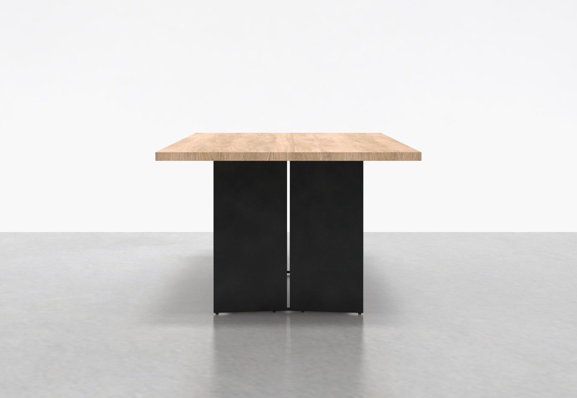 Two angled steel plates stand side by side on each end of our Milo Table, creating a clean contemporary form with ample clearance for legs and feet. The solid wood surface sits elegantly atop the base, creating a true sculptural element in any