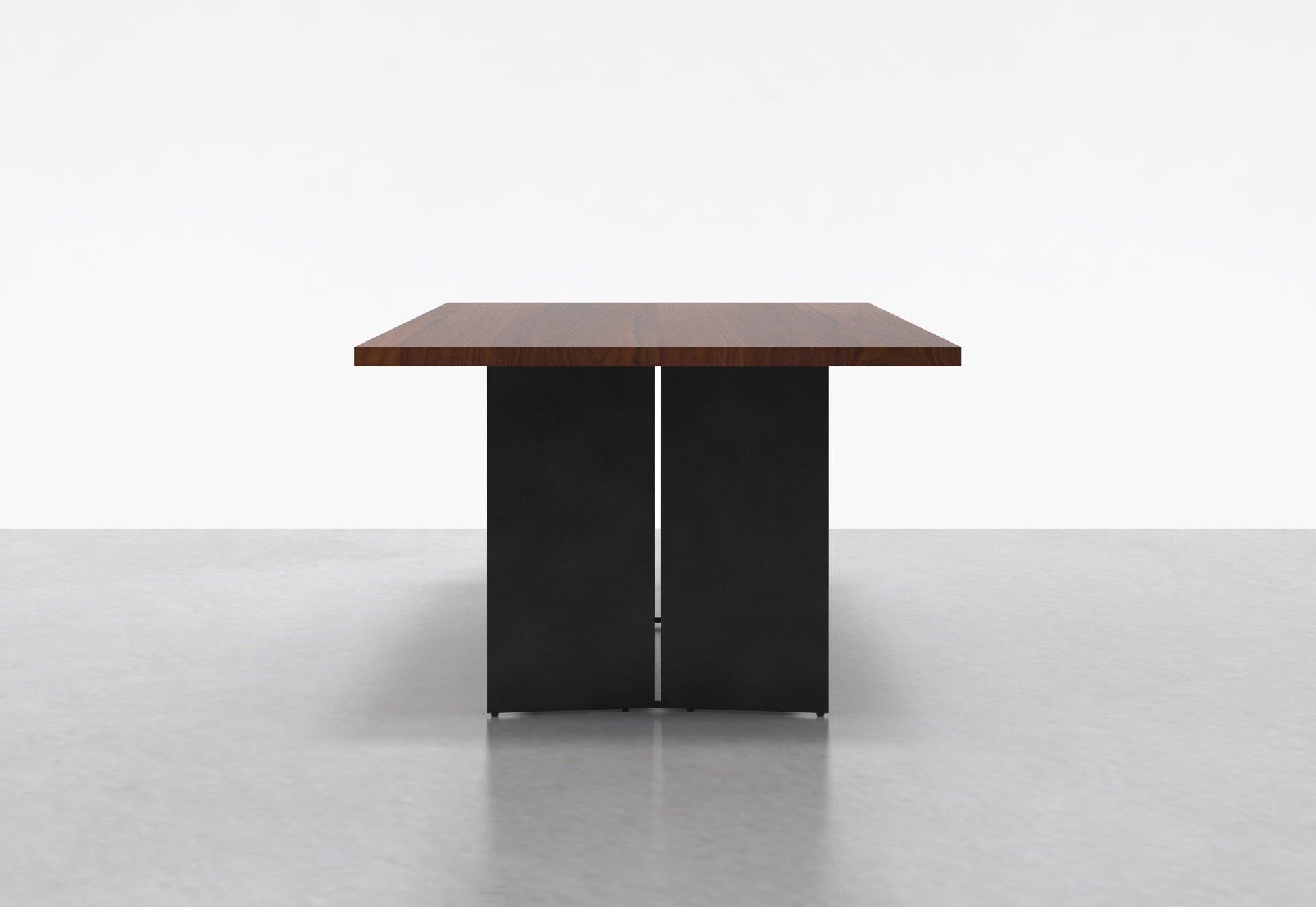 Two angled steel plates stand side by side on each end of our Milo Table, creating a clean contemporary form with ample clearance for legs and feet. The solid wood surface sits elegantly atop the base, creating a true sculptural element in any