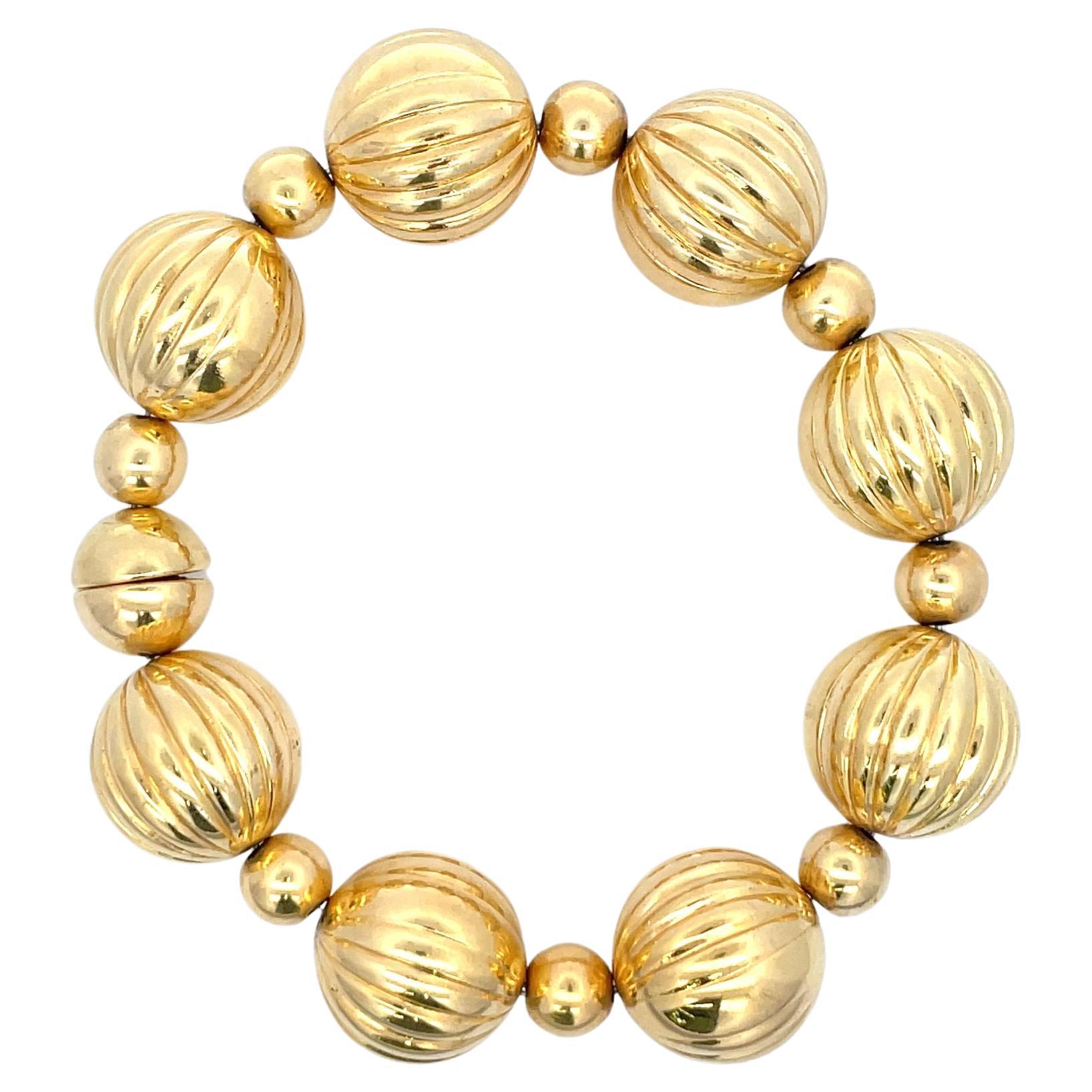 Milor 14 Karat yellow gold bracelet featuring 8 large ball motifs measuring 17.5 mm in between smaller balls measuring 7.6 mm weighing 31.2 grams, magnet closure. 
More link bracelets available.
Search Harbor Diamonds