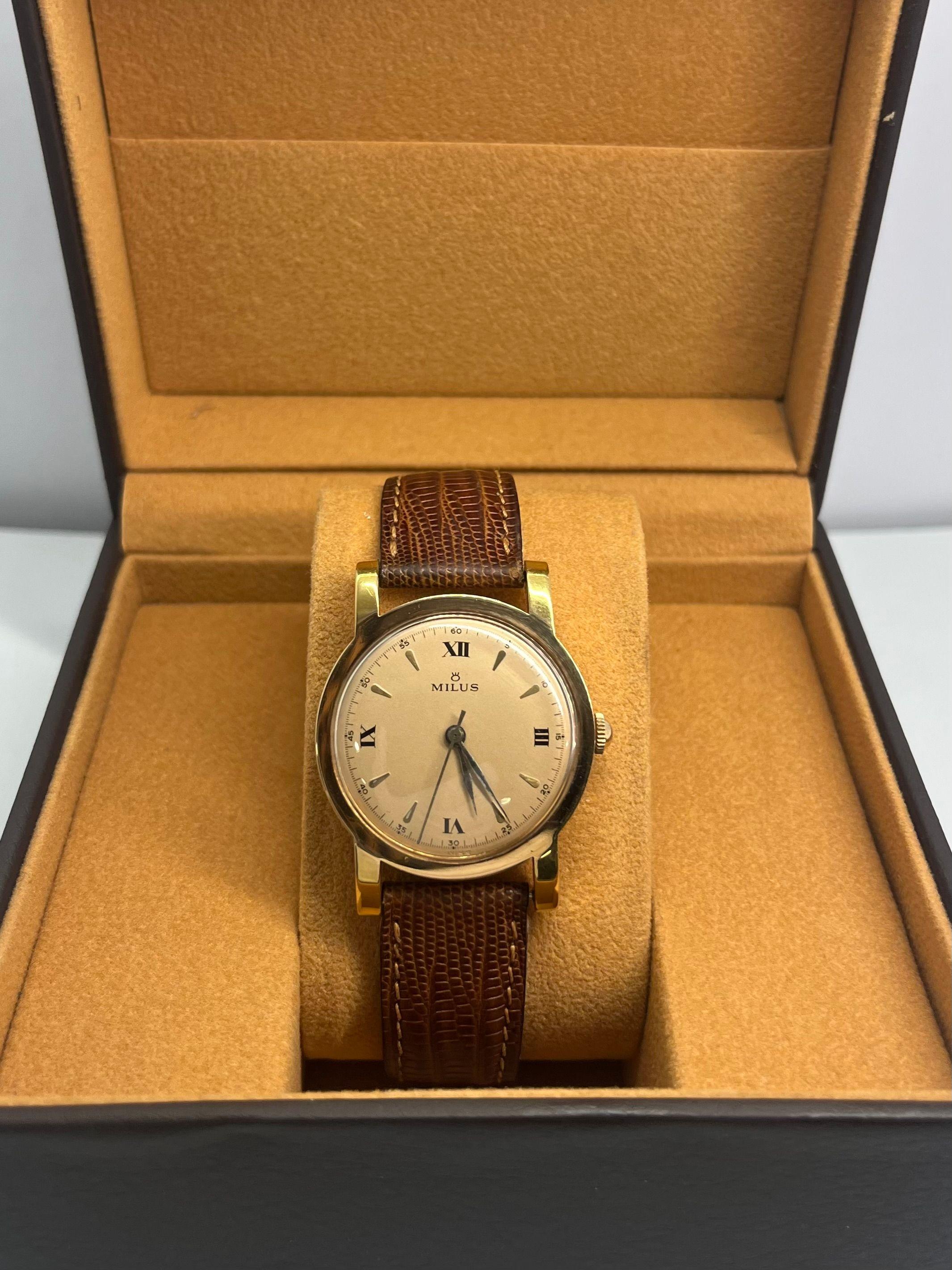 Descubre este reloj Milus vintage, de una renombrada maison suiza célebre por su refinada artesanía y sus meticulosos acabados. Este raro modelo cautiva con su caja completa de oro amarillo de 18 quilates, de líneas clásicas y elegantes que encarnan