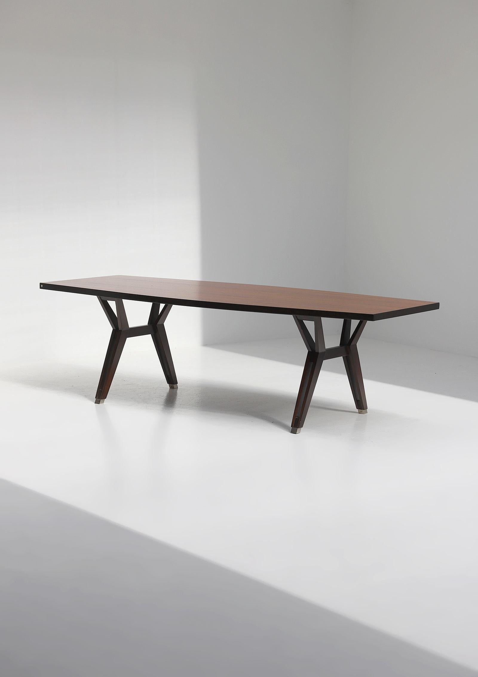 This rare dining / conference table has been designed in the late 50s and produced by MIM - Mobili Italiani Moderni Furniture. The exclusivity of this table is due to its boat shaped table top and material use. Eye catcher are the aluminum feet who