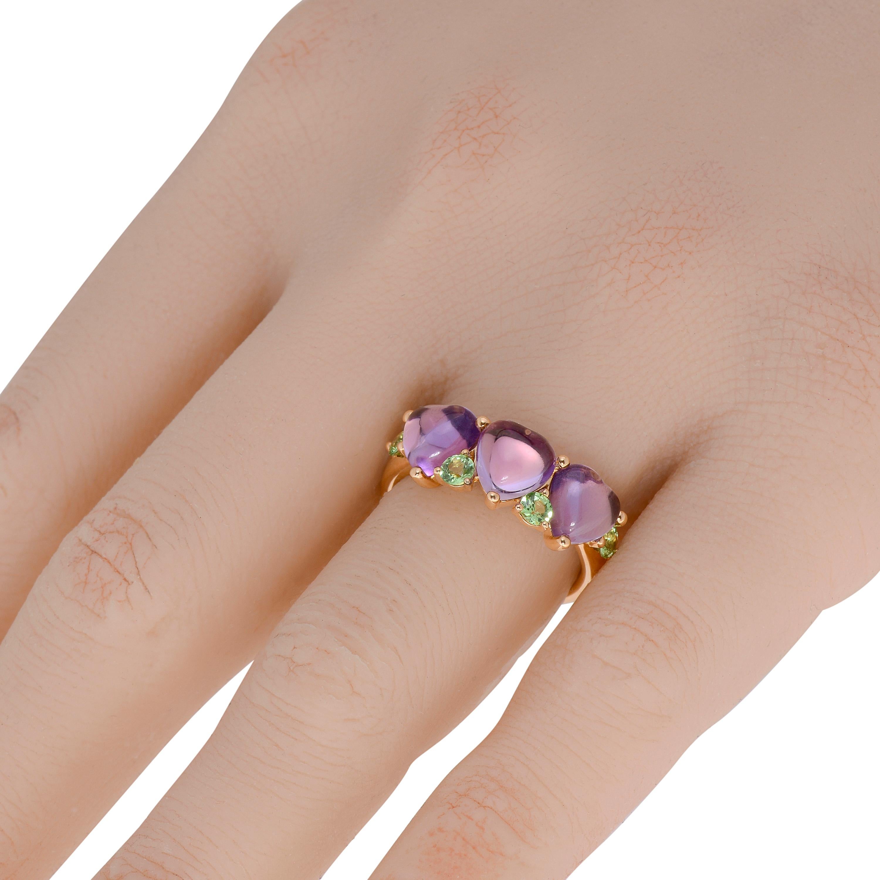 This bejeweled Mimi Milano 18K rose gold trilogy ring features 3.63ct. tw. cabochon amethyst with vibrant accents of 0.56ct. tw. round tsavorite. The ring size is 7. The decoration size is 7/8