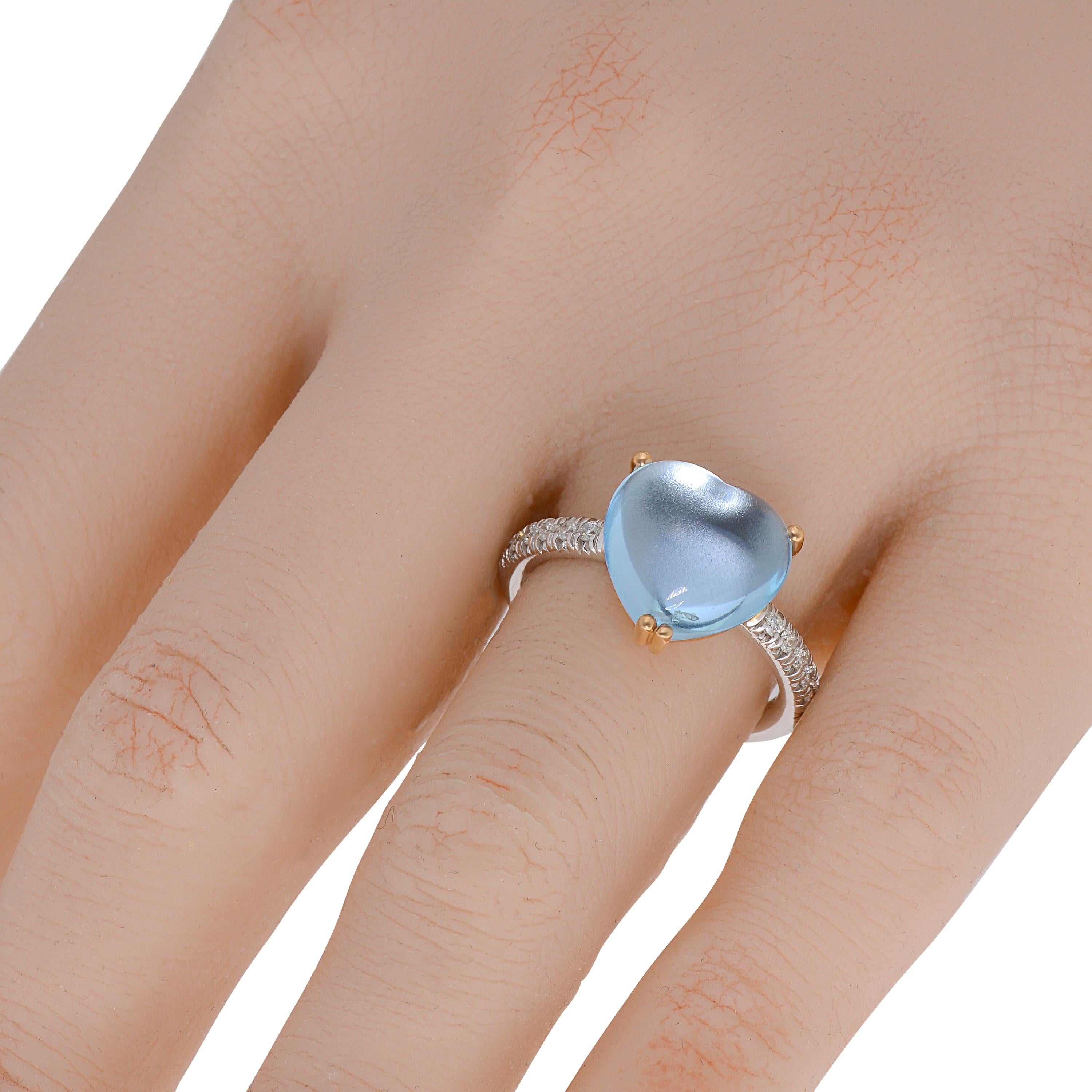 Der Mimi Milano Halo-Ring aus 18 Karat Weiß- und Roségold mit 0,18 Karat (tw.) Diamanten umschmeichelt einen 7,28 Karat (tw.) großen Blautopas-Cabochon, der in Roségold gefasst ist. Der Ring hat die Größe 7, die Dekoration ist 1/2