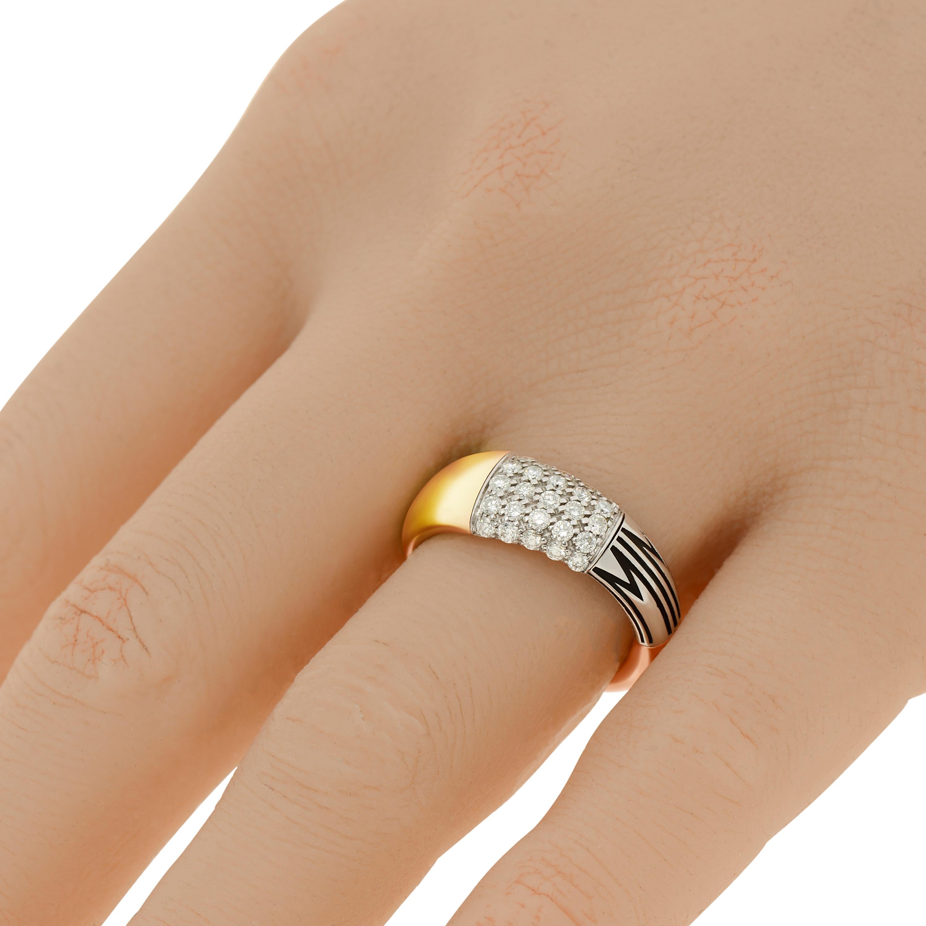 Mimi Milano Tam Tam 18k yellow gold and 18k white gold band ring features 0.55ct. tw. diamonds set in a two toned band. The ring size is 7 (54.4). The band width is 1/4