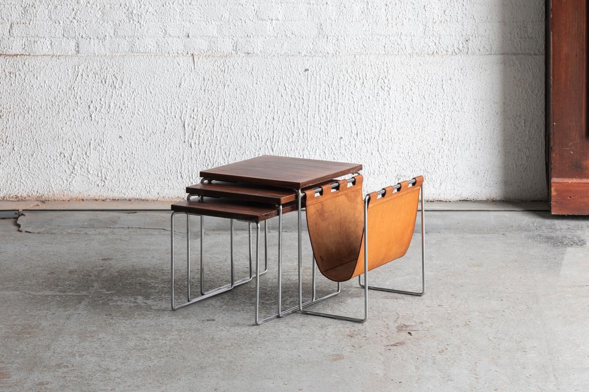 Set nesting tables produced by Brabantia in the Netherlands around 1960. This set features chromed legs, tabletops in rosewood veneer and a leather magazine holder. In good condition with some using marks as shown in the pictures.

H: 30 / 34 / 37
