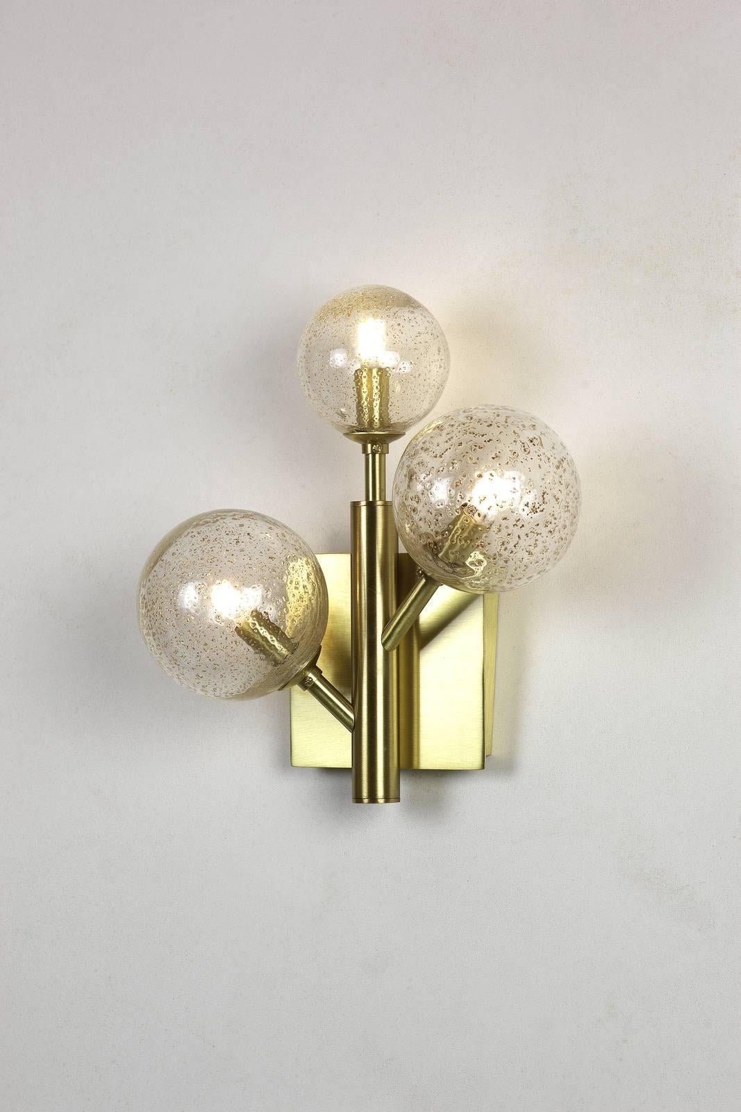 Entirely handcrafted in Murano, the lines and globes of this sophisticated sconce designed by Alberto Donà are reminiscent of the mimosa flower from which the collection takes its name. This elegant lighting fixture has a metal structure in the