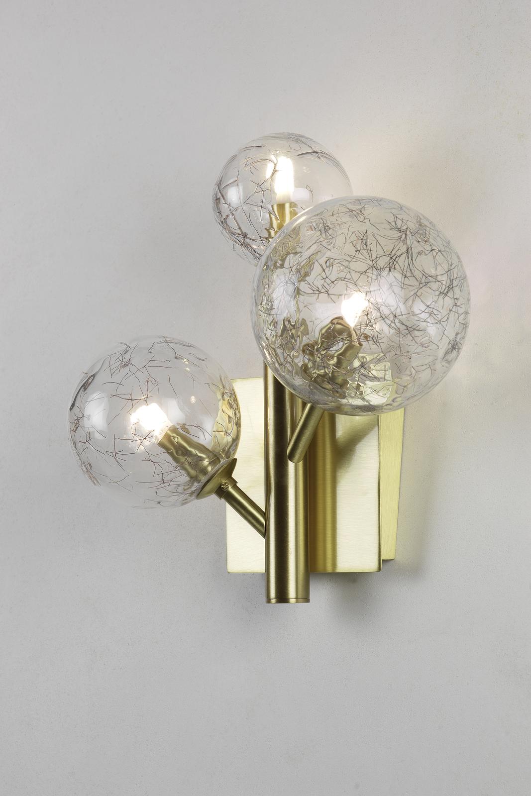 The delicate silhouette of this elegant wall light makes it perfect for illuminating intimate spaces in the home or office. Mounted on a square brass finished base, is a linear brass structure with two extending arms, all bearing a lustrous finish.