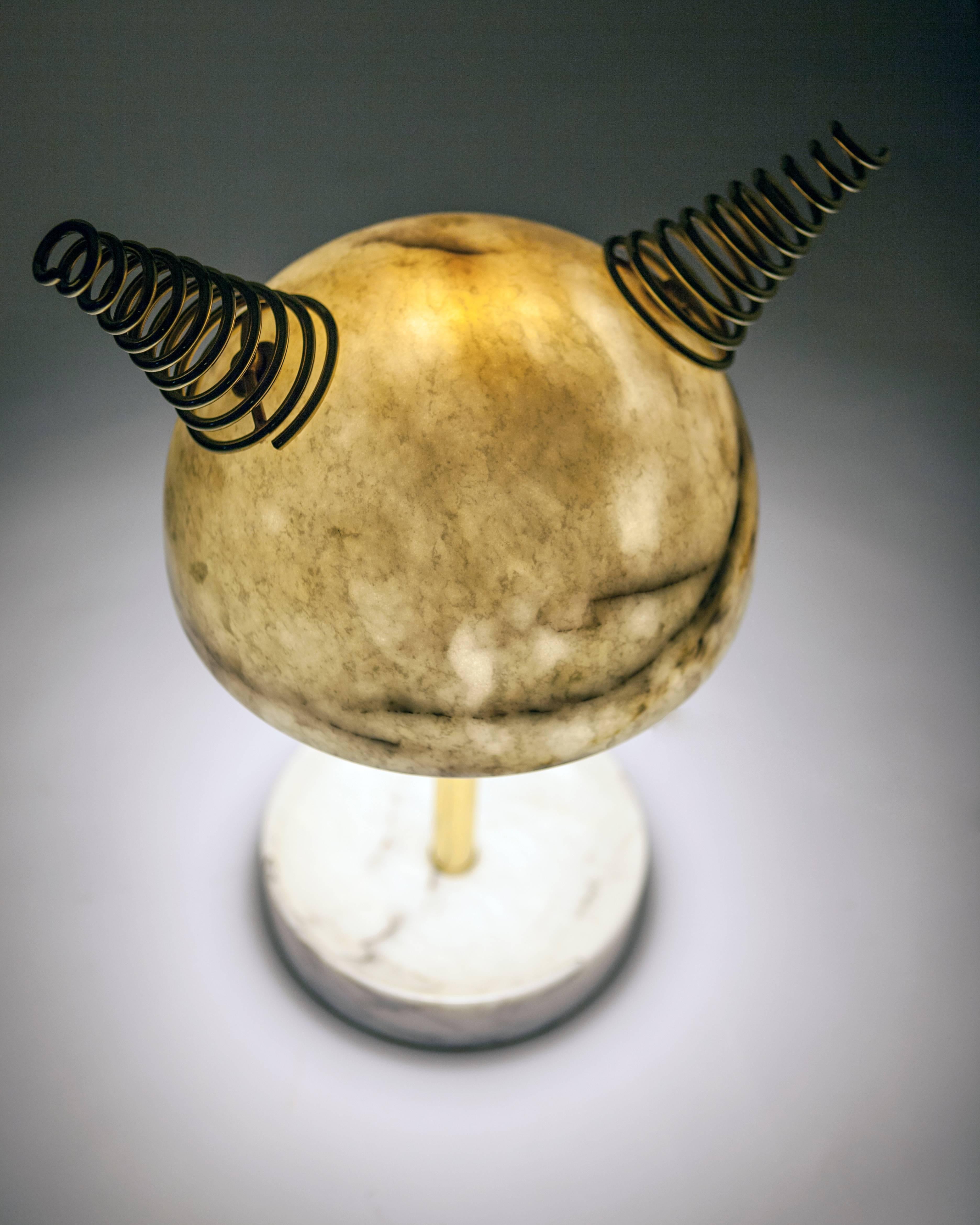 Min Lilla Anime is the new version of the Min Lilla Viking lamp. Horns are replaced with the swivel metal strings resembling the hair of the Japanese anime characters. Veins of the Leylak marble gives out a purplish hue and the metal color can be