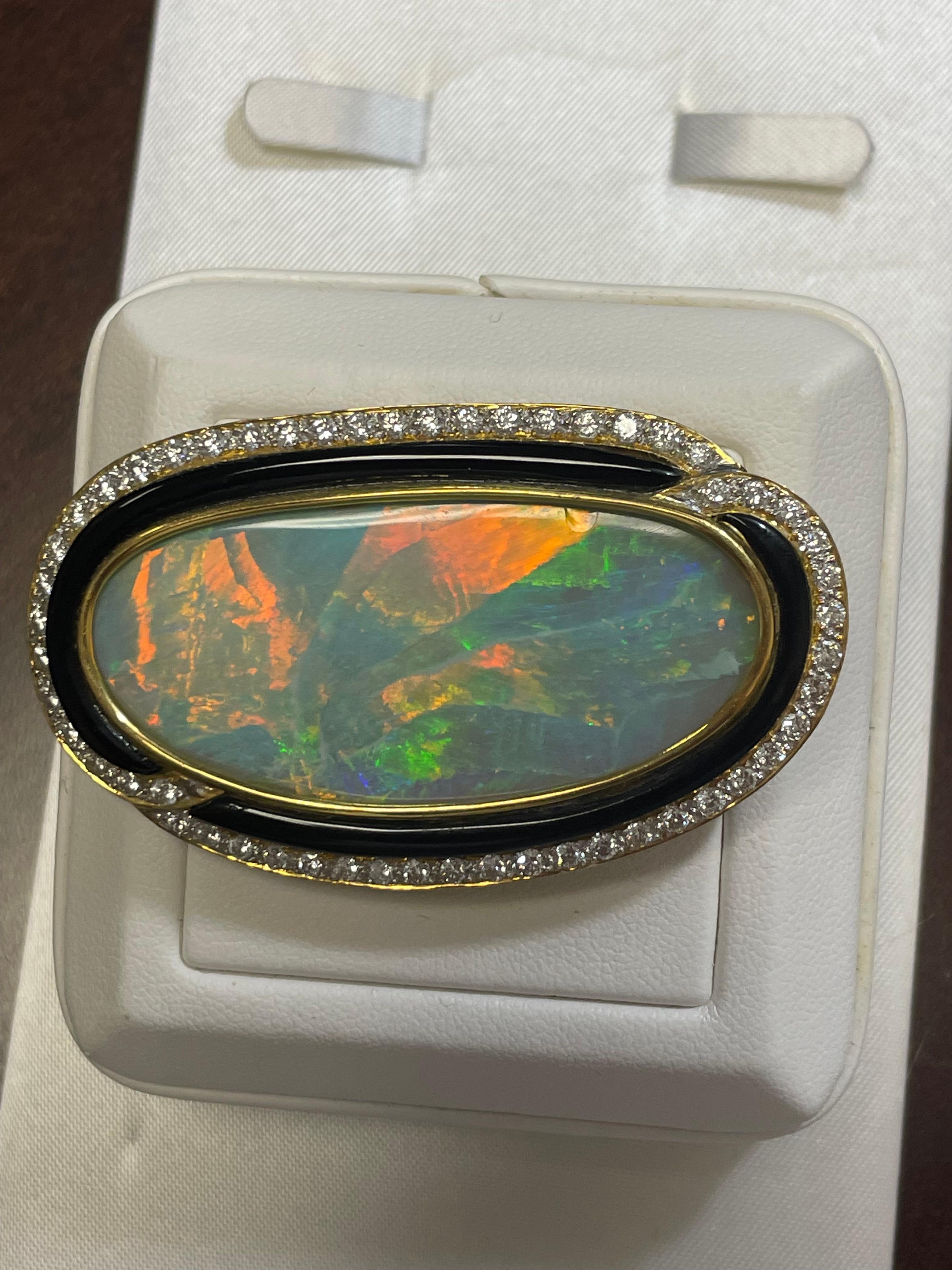 One lady's semi-black peacock opal with multicolor fire pattern.  Saturation scale is vivid with a large flash fire pattern.  Extremely bright with cabochon, oval shape.  Measurements are 46.0 mm x 21.0 mm. 54 round brilliant cut diamonds measuring