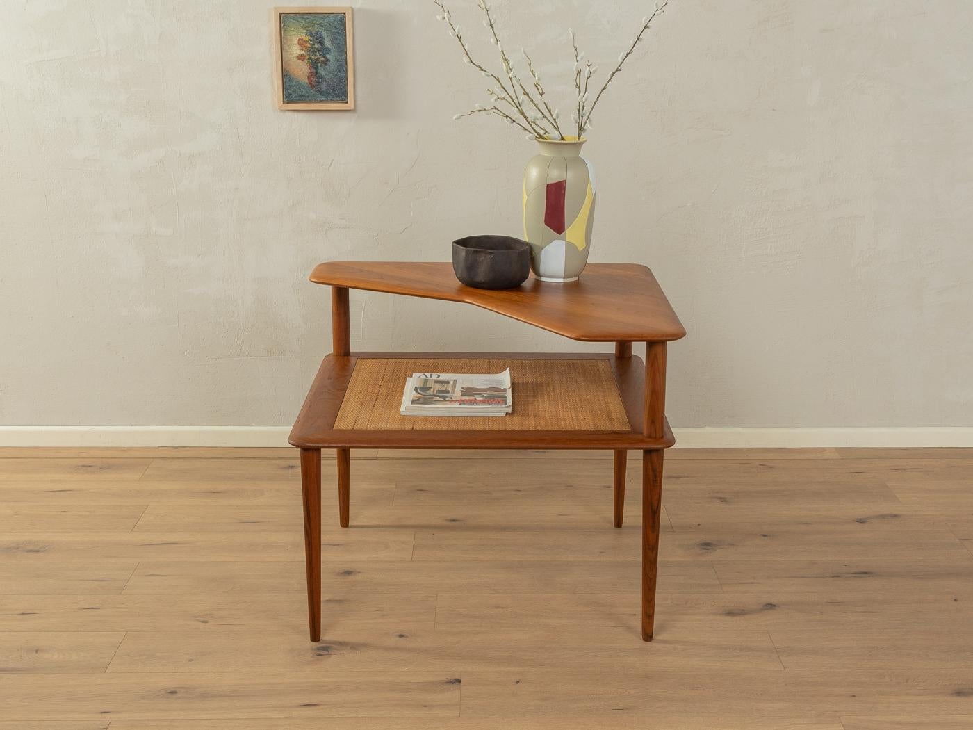 Wonderful Minerva coffee table by Peter Hvidt & Orla Mølgaard-Nielsen for France & Son from the 1960s. High-quality solid wood frame made of teak with a shelf made of braided reed.

height table top: 42 cm

Quality Features:
    accomplished design: