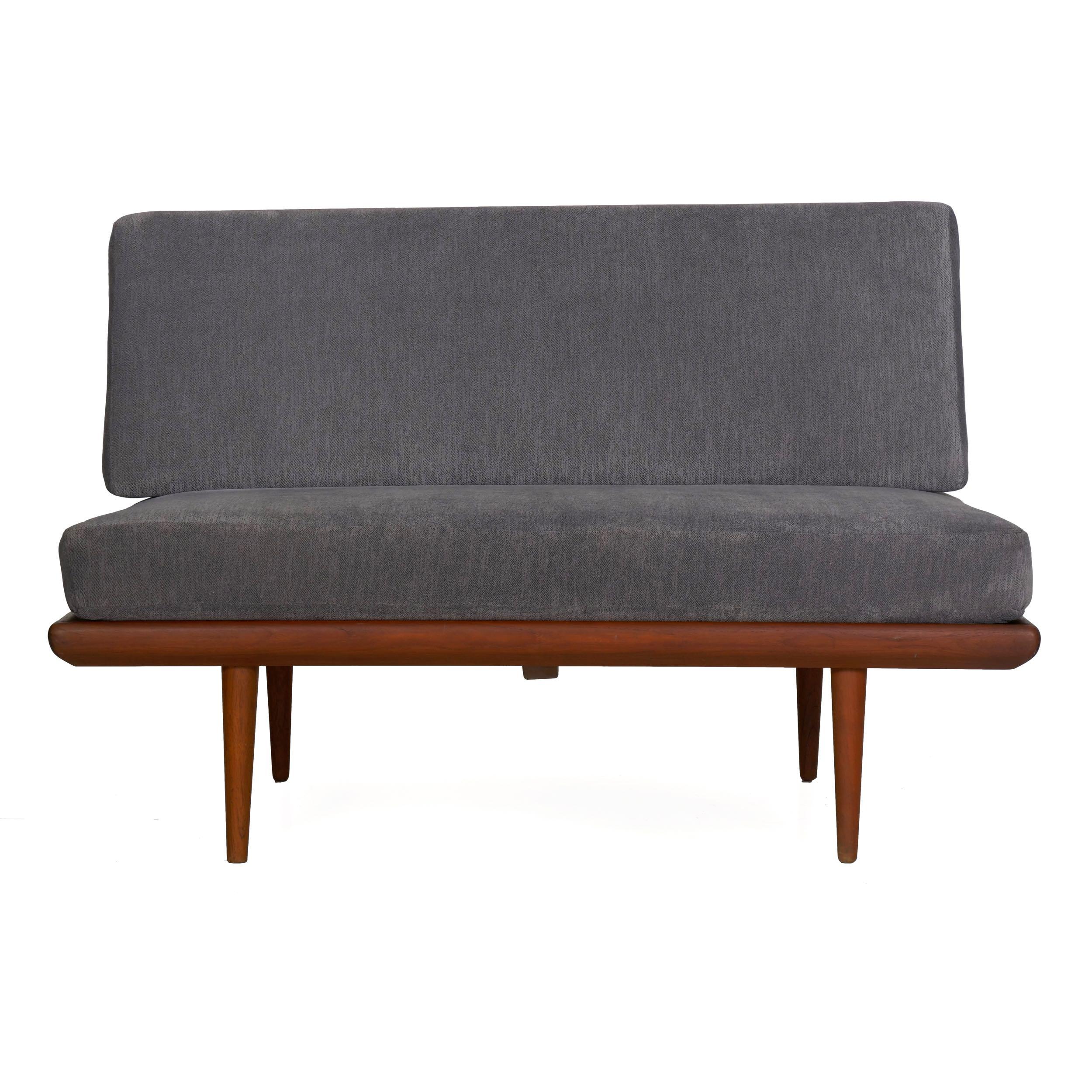 Designed in the 1960s by Peter Hvidt and Orla Mørlgaard-Nielsen for production by France & Sons of Denmark, this sleek and streamlined two-seat daybed loveseat is executed in thick solid teak. An unusual and distinctive form, iron brackets rise from