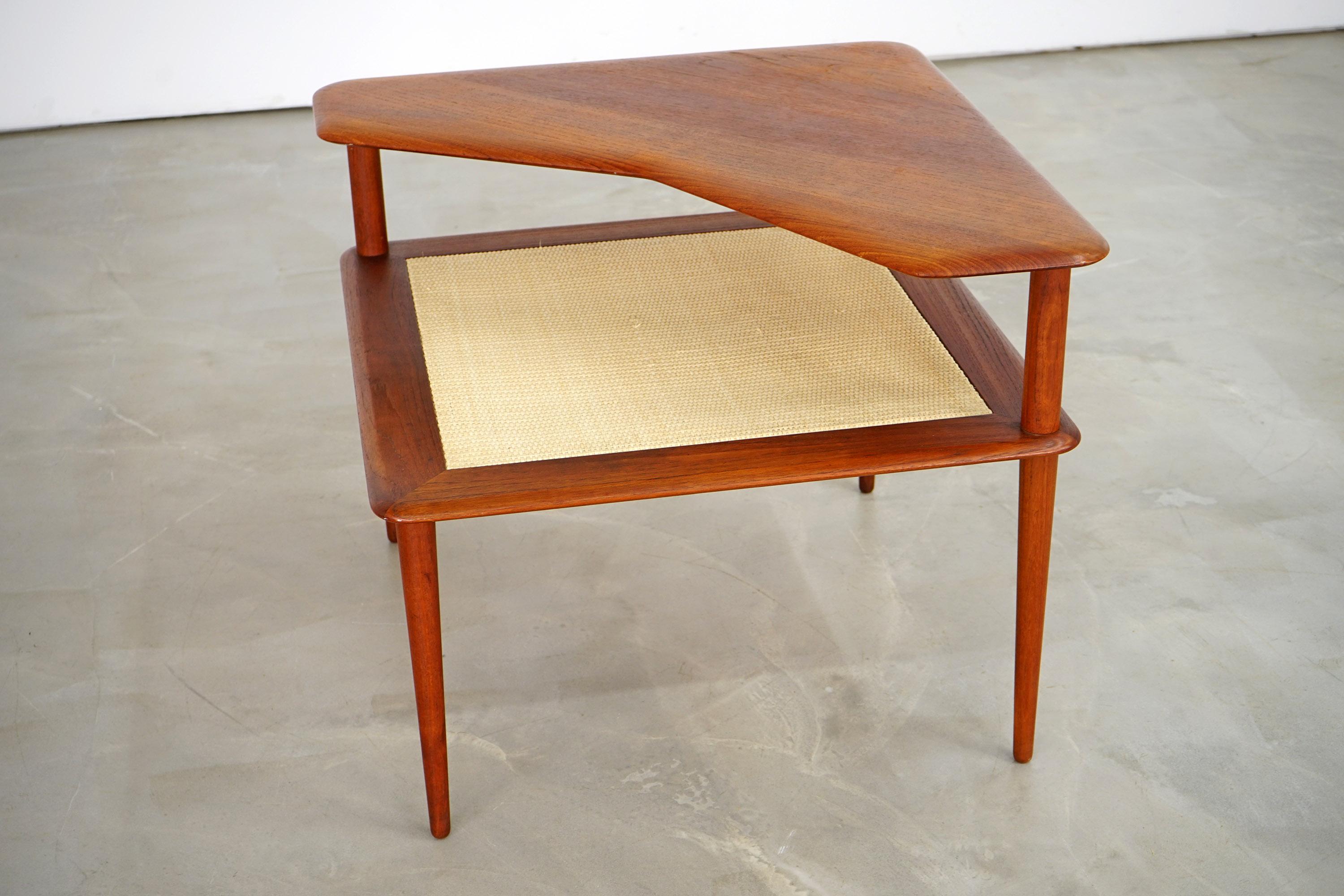 The two-story Minerva series side table was designed by Peter Hvidt and Orla Mølgaard Nielsen and manufactured by France & Daverkosen in the 1960s. It was labelled by the manufacturer on the bottom. The elegantly designed piece is made of teak wood