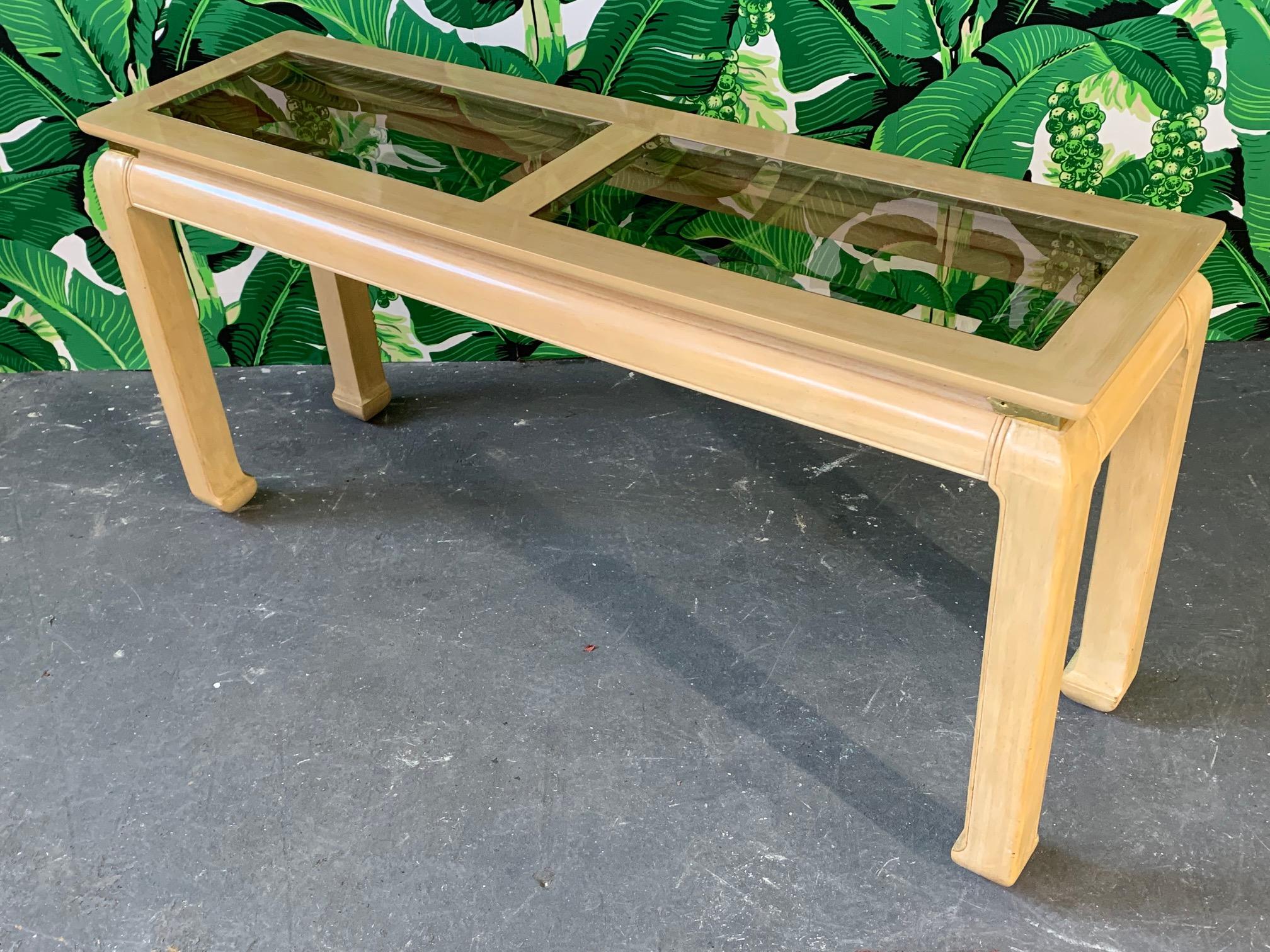 Ming Asian console table by Bernhardt features beveled smoked glass inserts and brass detailing. Very good vintage condition with minor signs of age appropriate use.