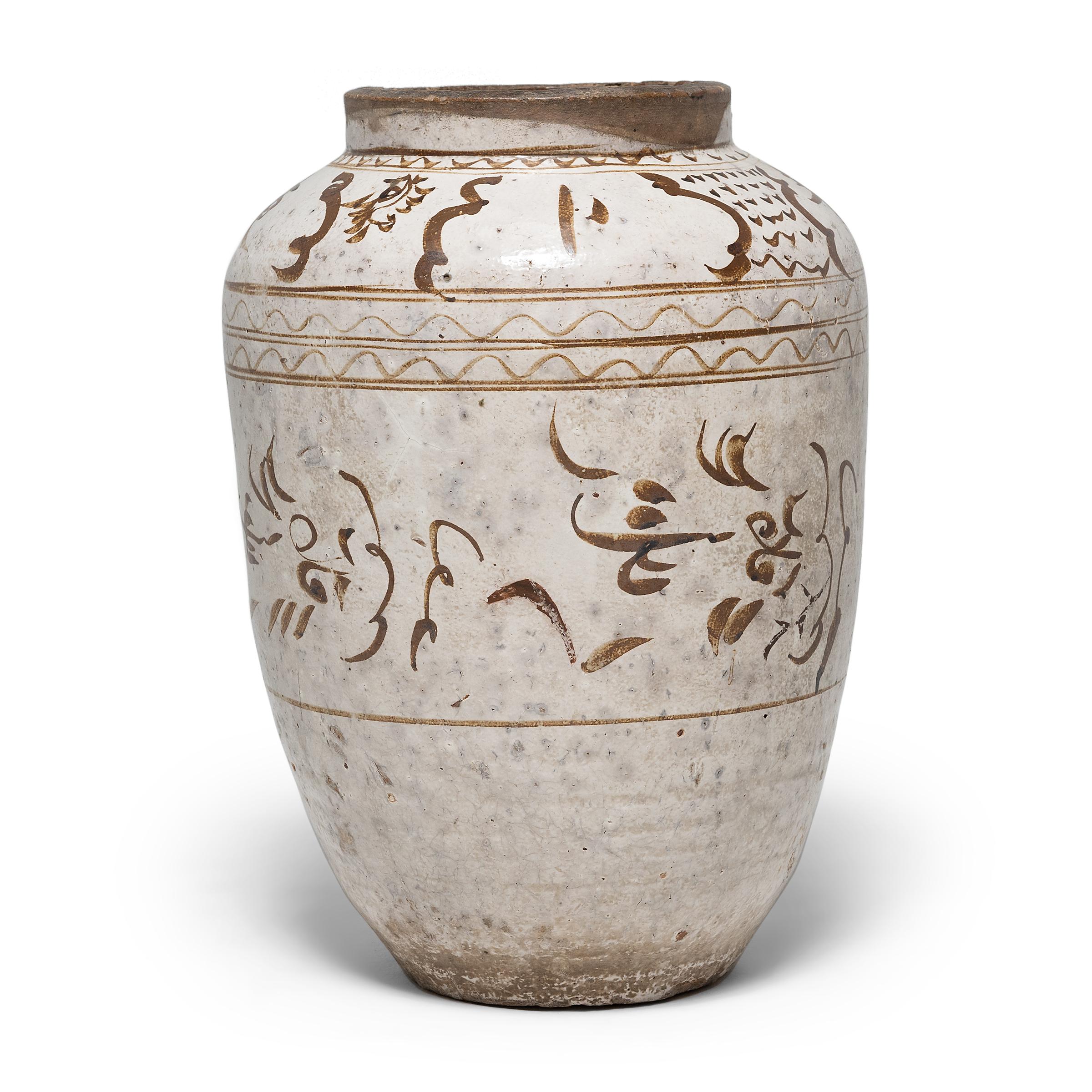Dieses beeindruckende glasierte Gefäß stammt aus dem frühen 17. Jahrhundert und wurde in einer Küche der Ming-Dynastie zur Aufbewahrung von Gewürzen oder Essiggurken verwendet. Das große Gefäß hat eine elegante, spitz zulaufende Form und ist mit