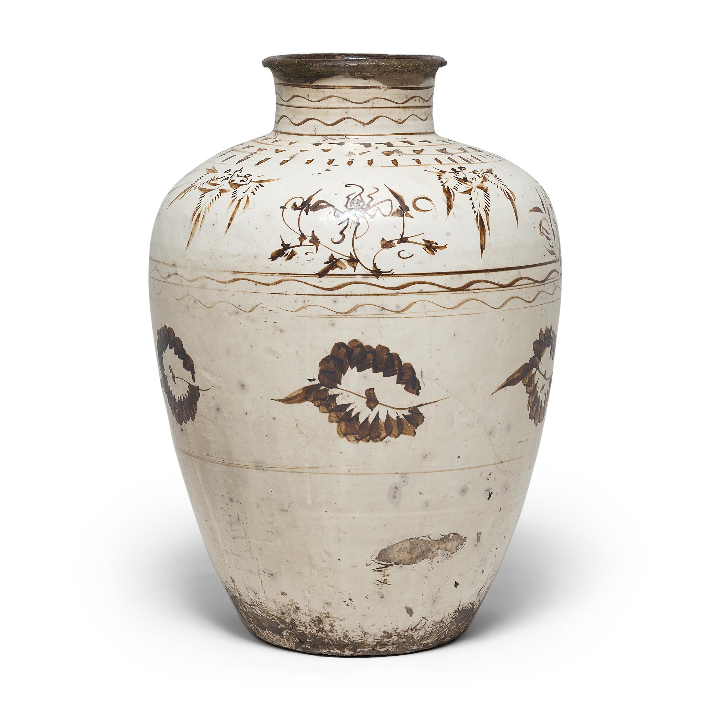This impressive glazed vessel dates to the early 17th century and was used to store wine and spirits made from rice and other grains. The Ming-dynasty jar has an elegant, tapered form and is beautifully glazed with neutral earth-tones in a style