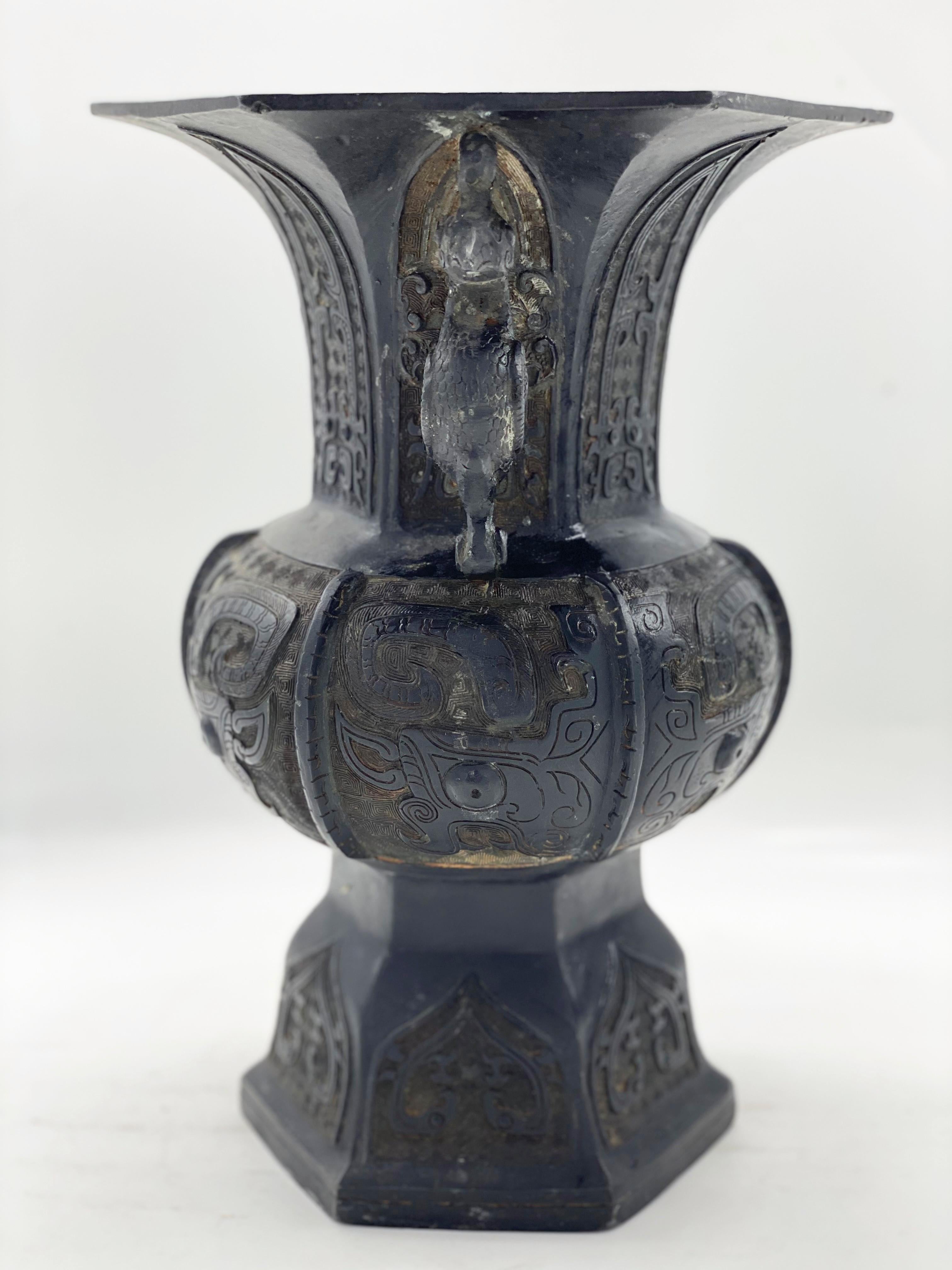 Double handle embossed Chinese bronze vase, phoenix handles, with geometric decoration of archaic inspiration, early Ming dynasty, 17th century. With a beautiful rich and antique dark patina.
The vase has a round belly that tapers upwards into a
