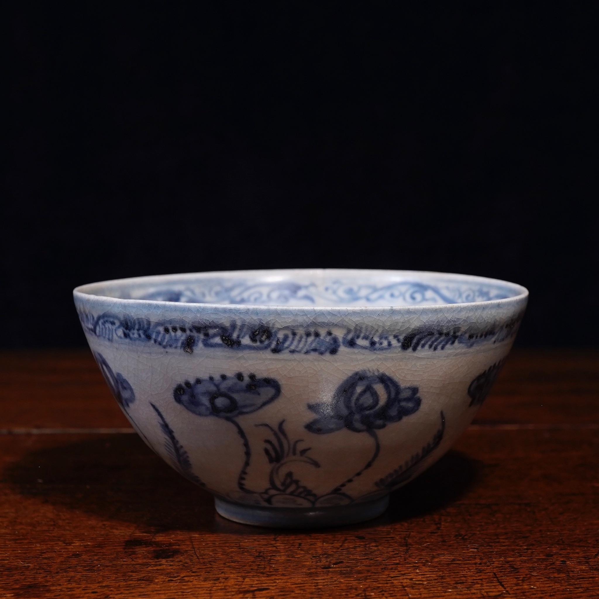 Chinese porcelain blue and white 'Lotus Pond' bowl, painted with a band of tall lotus blooms and fern-like foliage all spiraling in a clock-ways direction, a stylized foliage border to the rim echoed inside above a broad band of scrolling